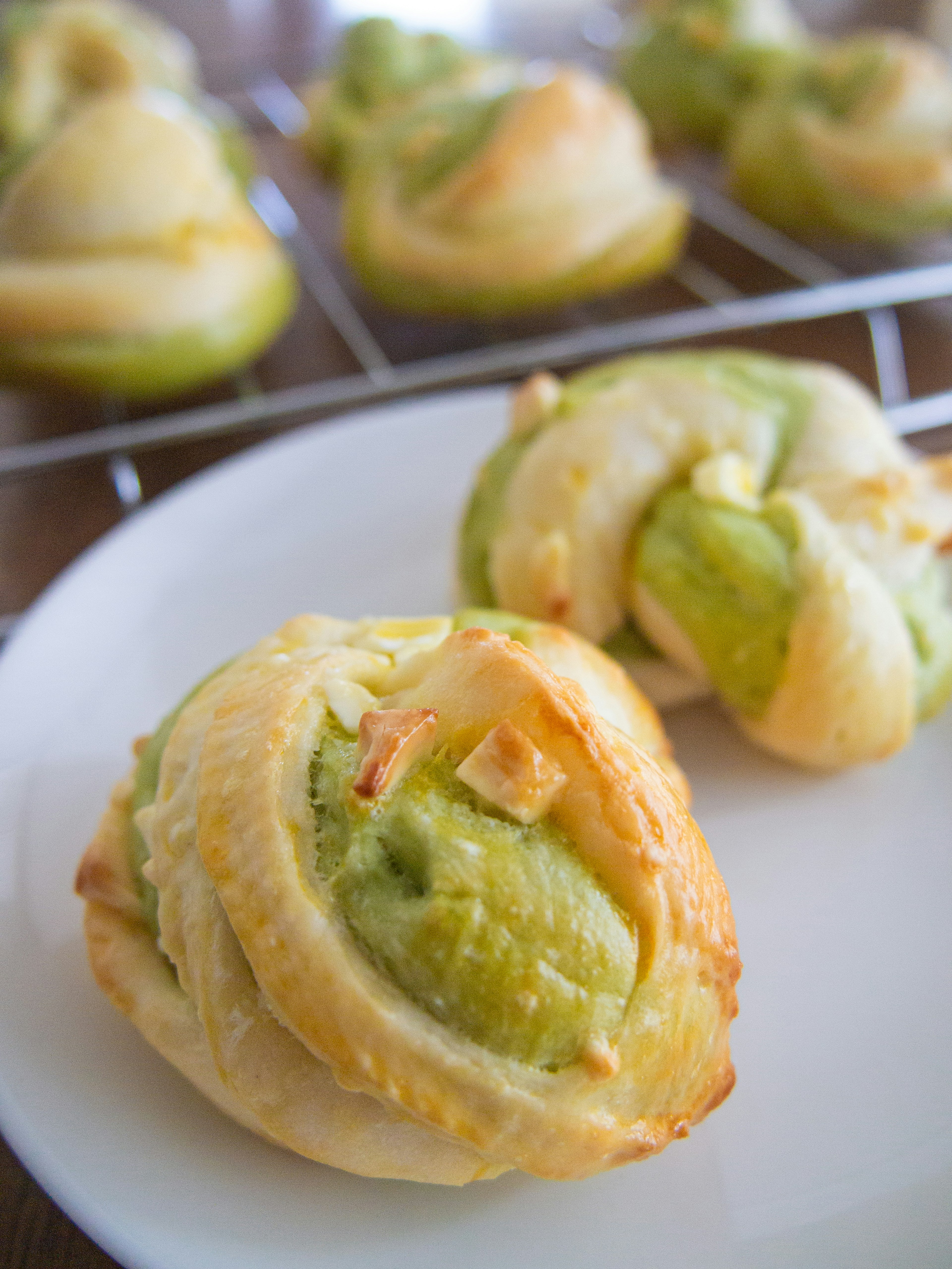 Rollos de masa rellenos de crema verde en un plato blanco