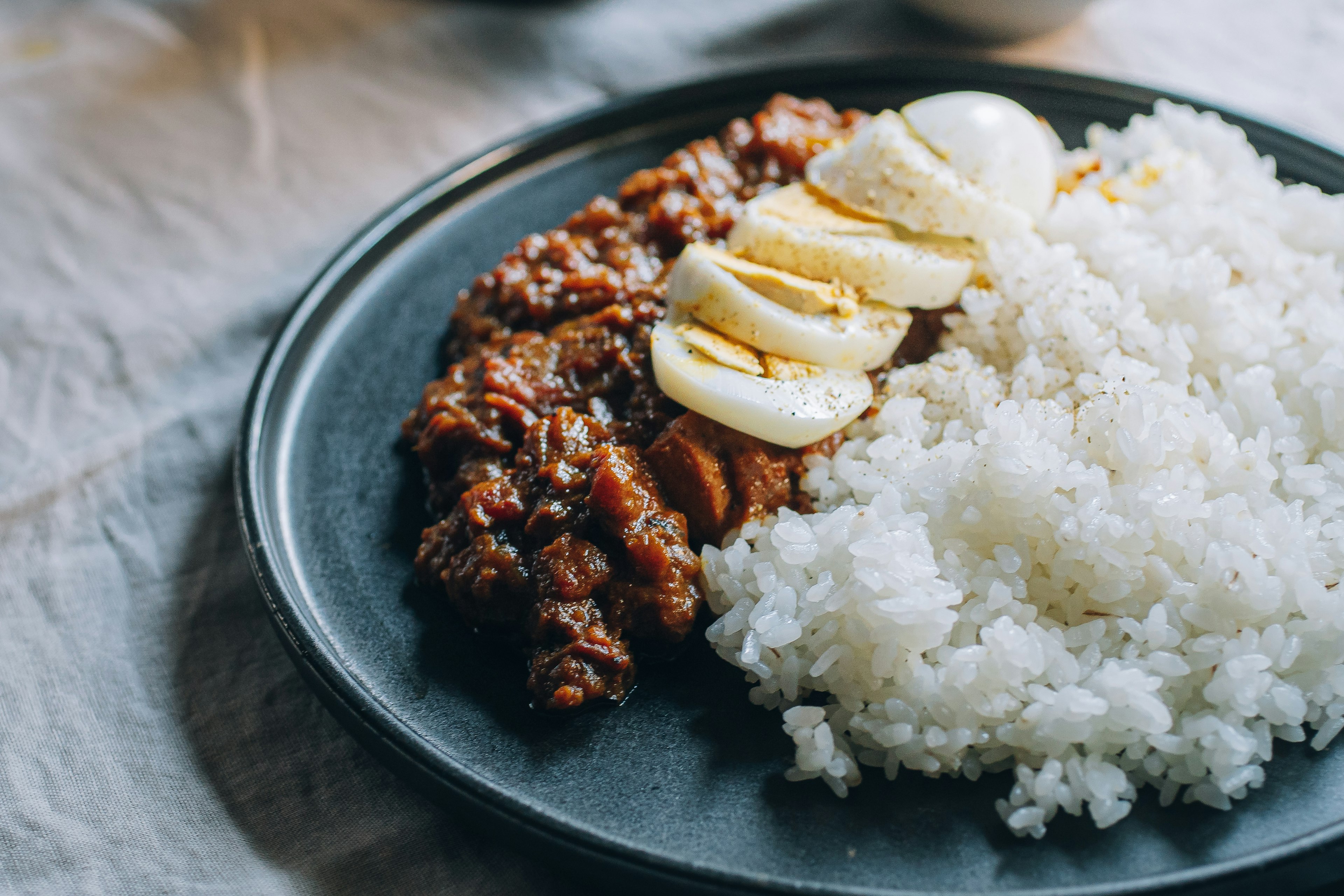 Teller mit Teriyaki-Hähnchen, garniert mit süßen Bananenscheiben und serviert mit weißem Reis