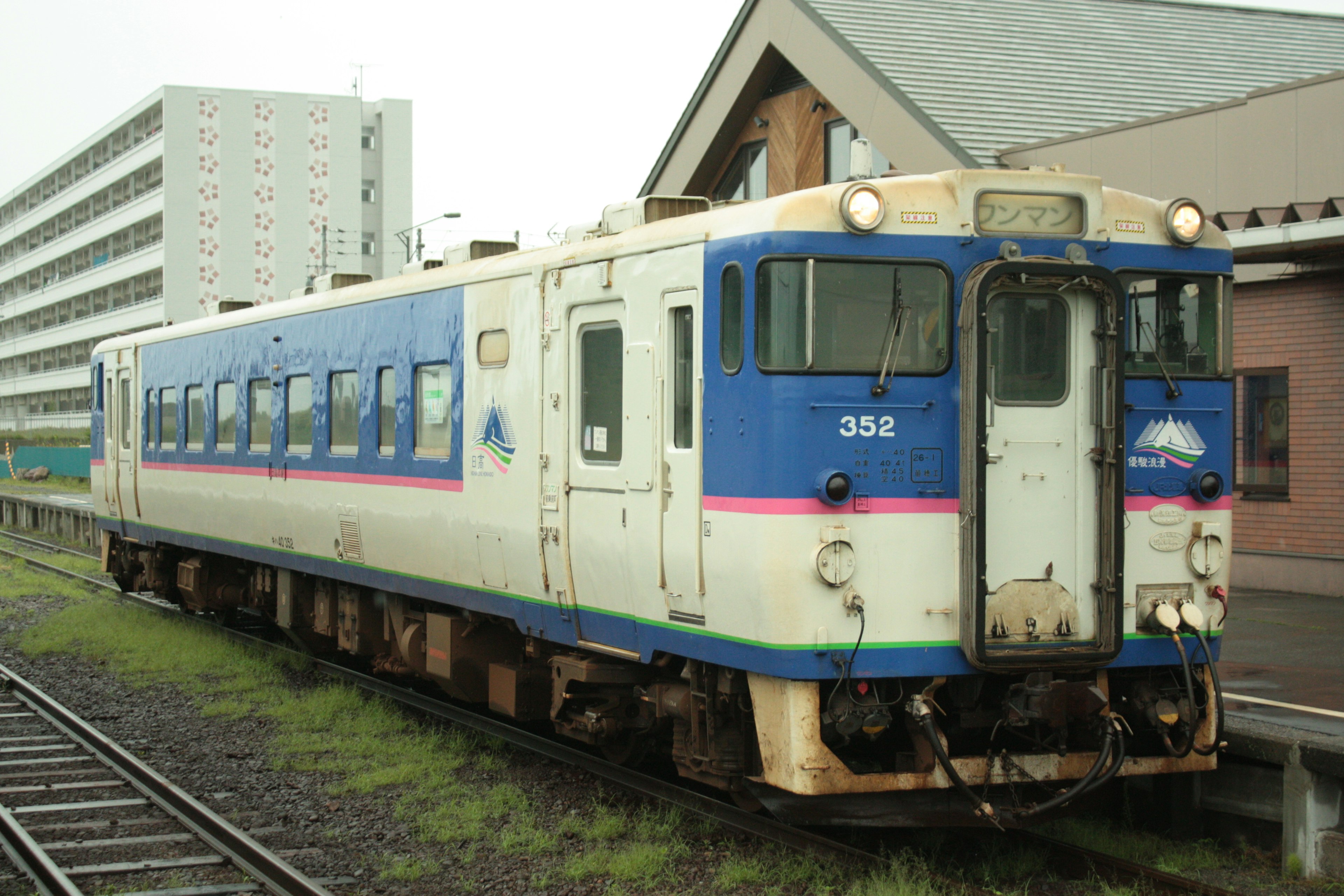 Un tren azul y blanco estacionado en una estación