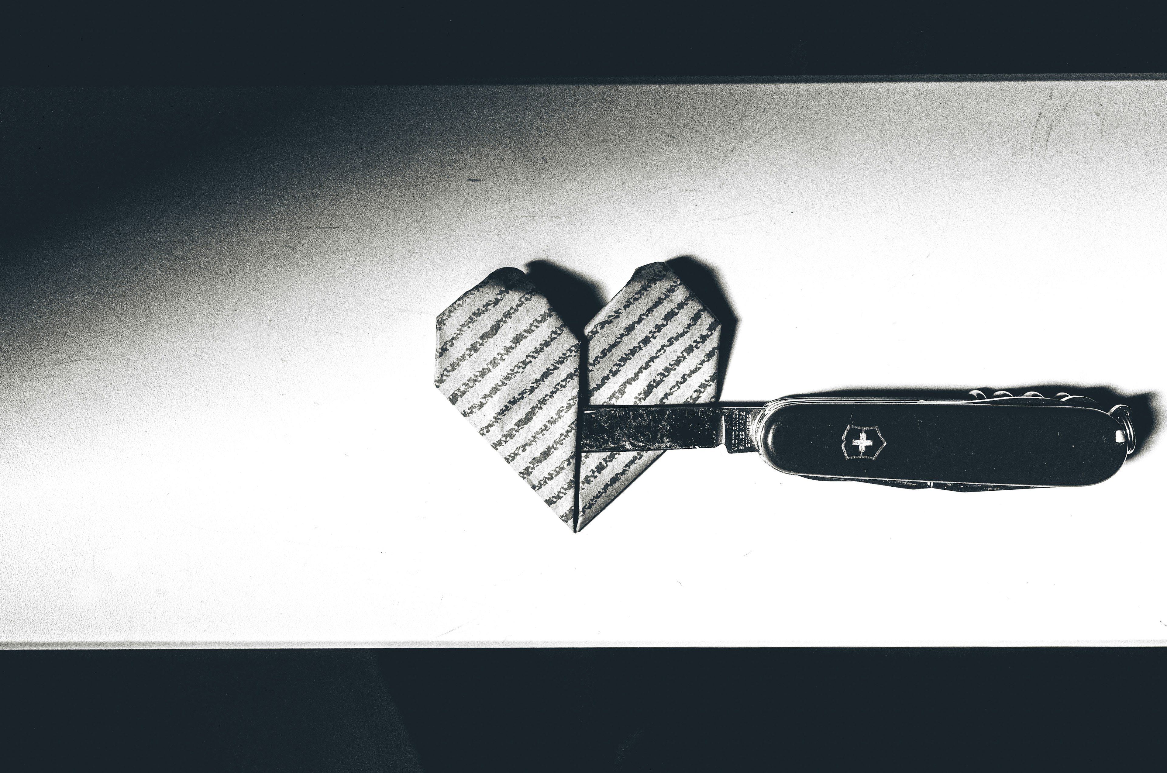 An image featuring a heart-shaped cutout next to a Swiss Army knife