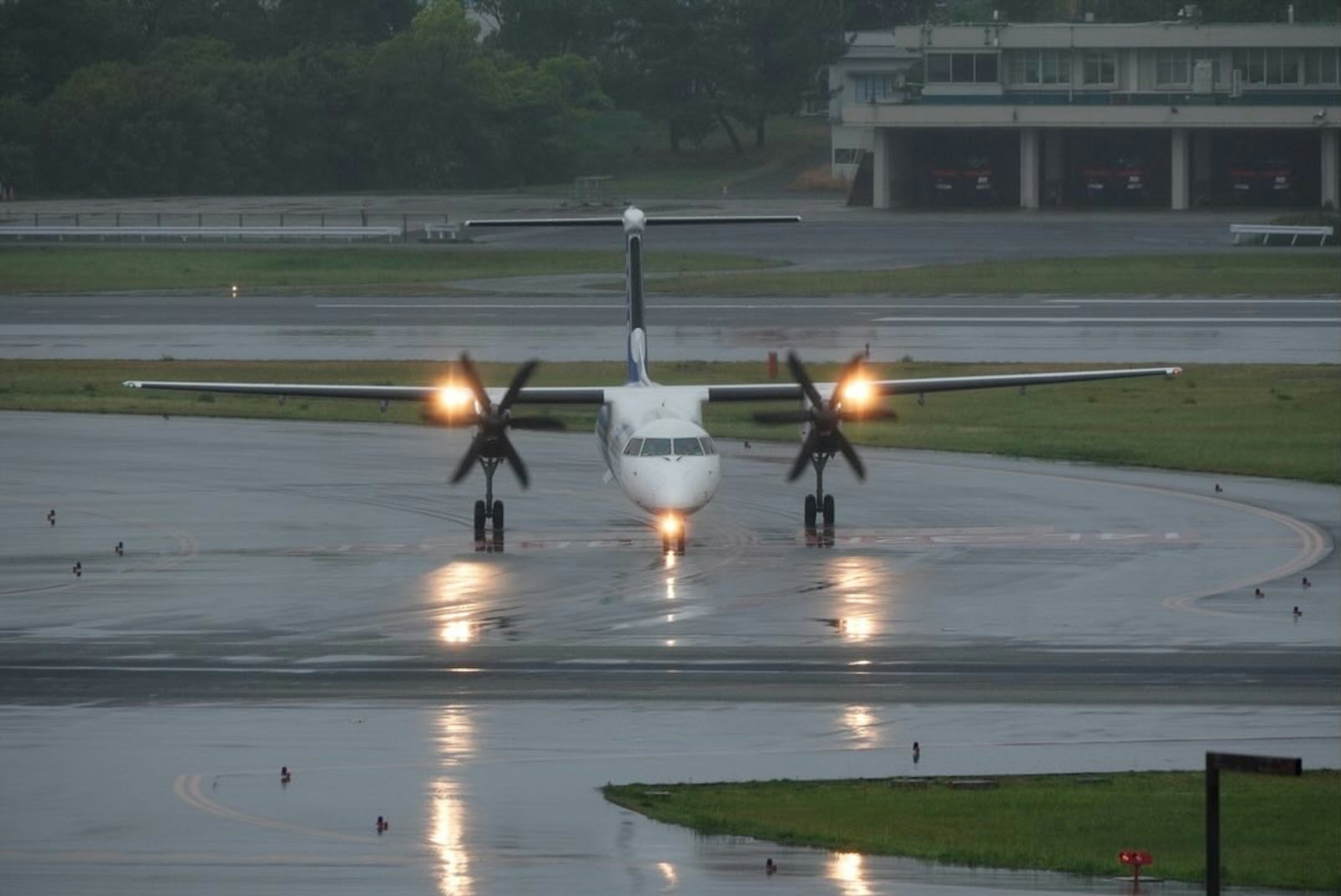 Avion à hélices sur la piste sous la pluie