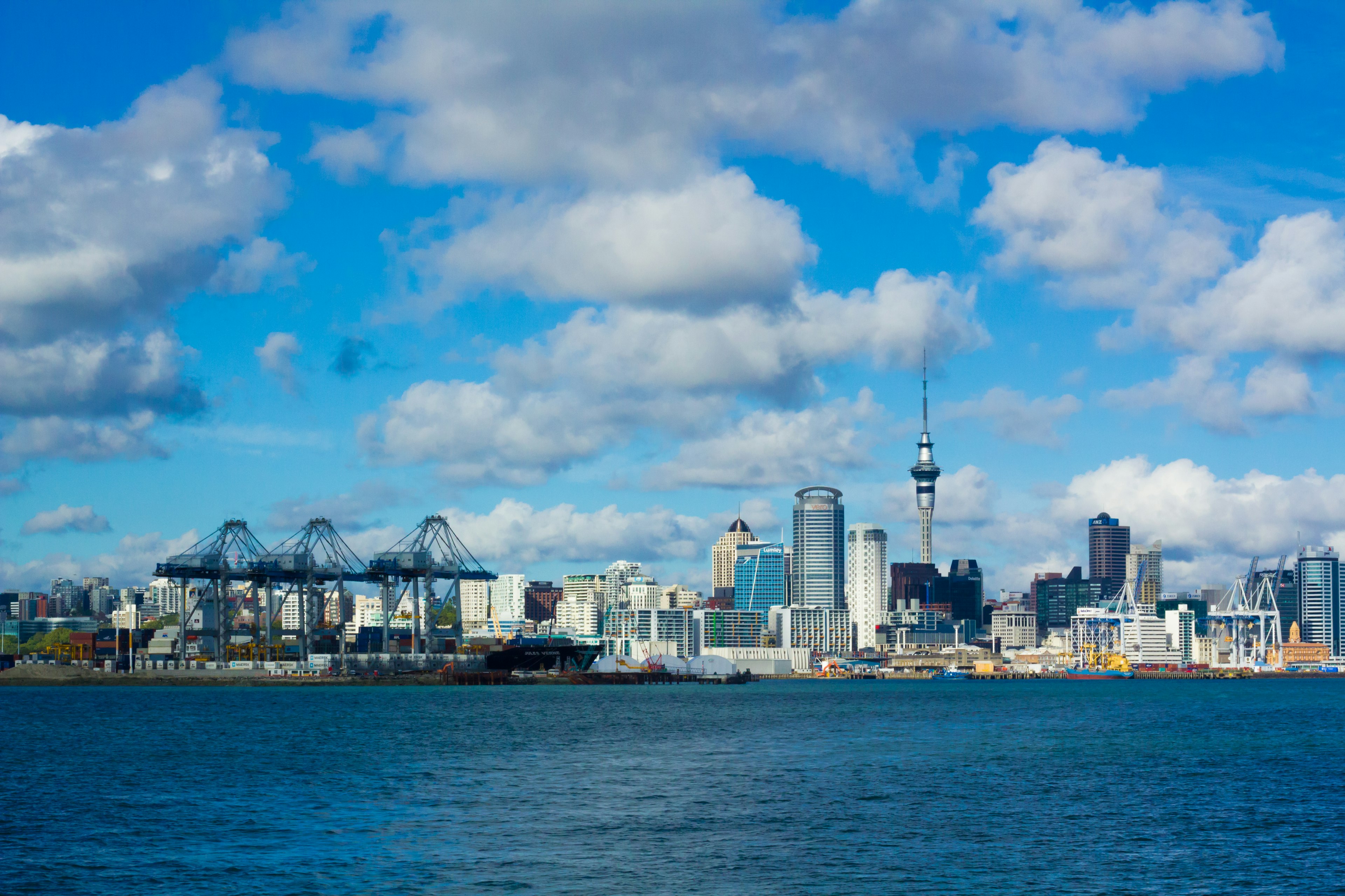 Garis langit Auckland dan pelabuhan di bawah langit biru dengan awan