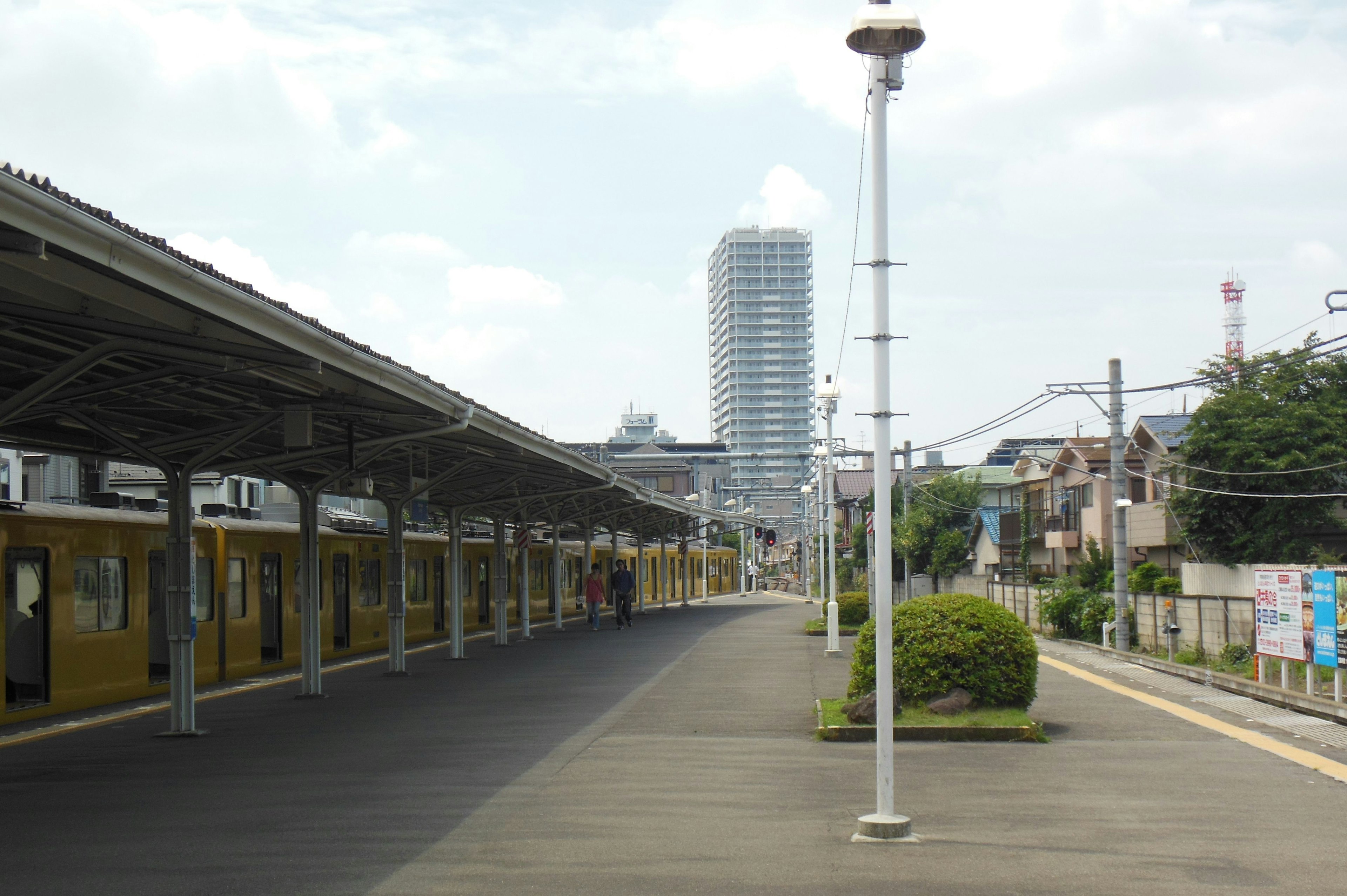 Yellow trains lined up on a train platform with a high-rise building in the background