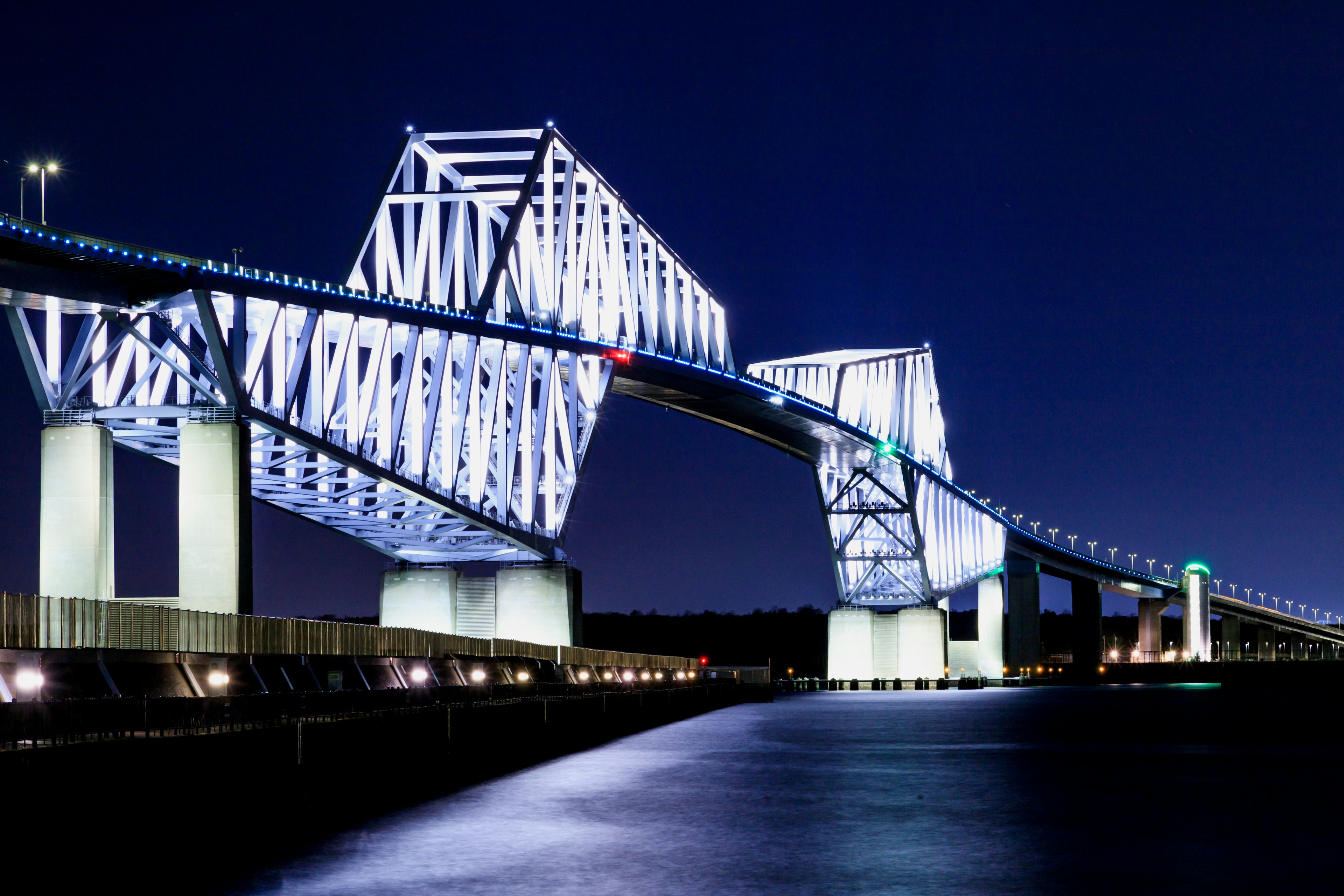 Una vista impresionante de un puente iluminado en azul y blanco por la noche