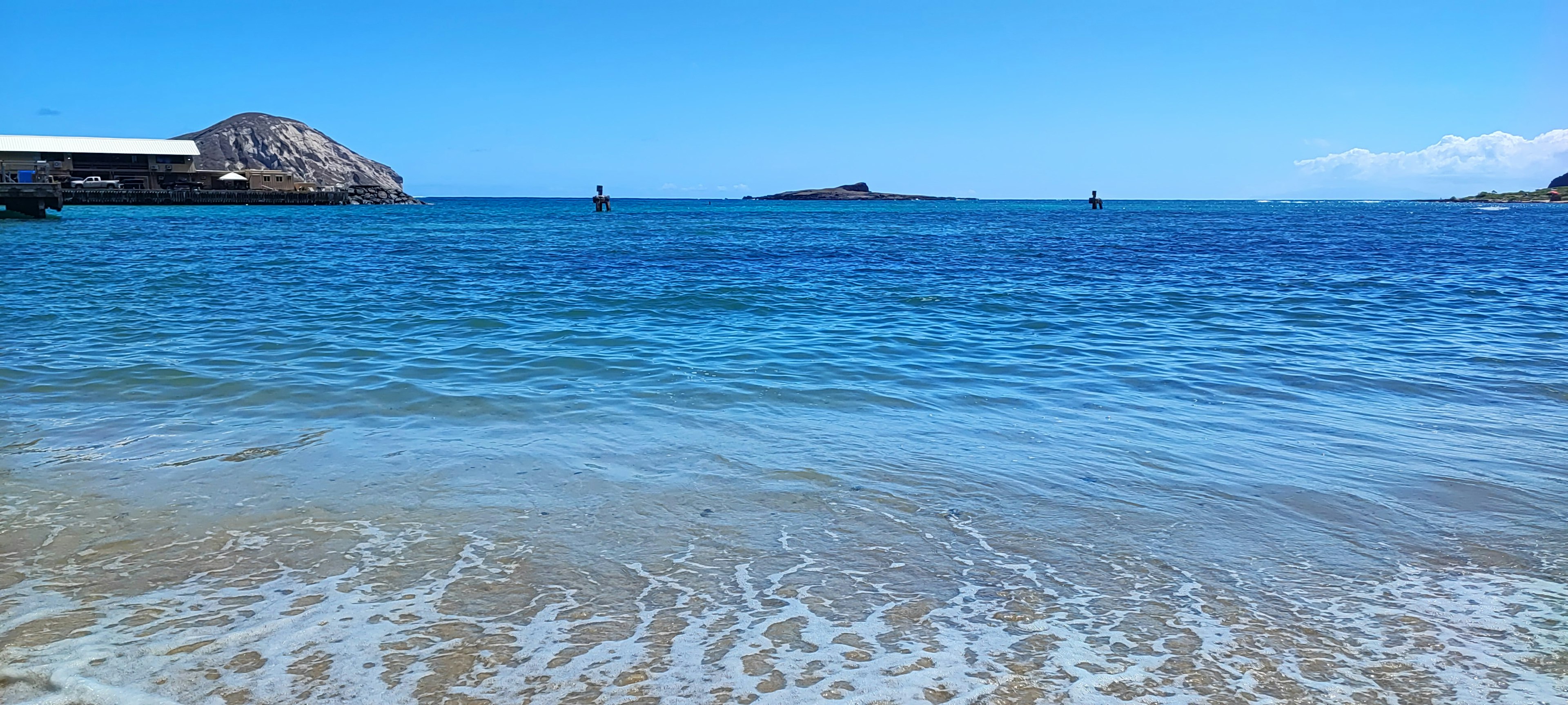 Pemandangan pantai yang indah dengan laut biru dan ombak putih