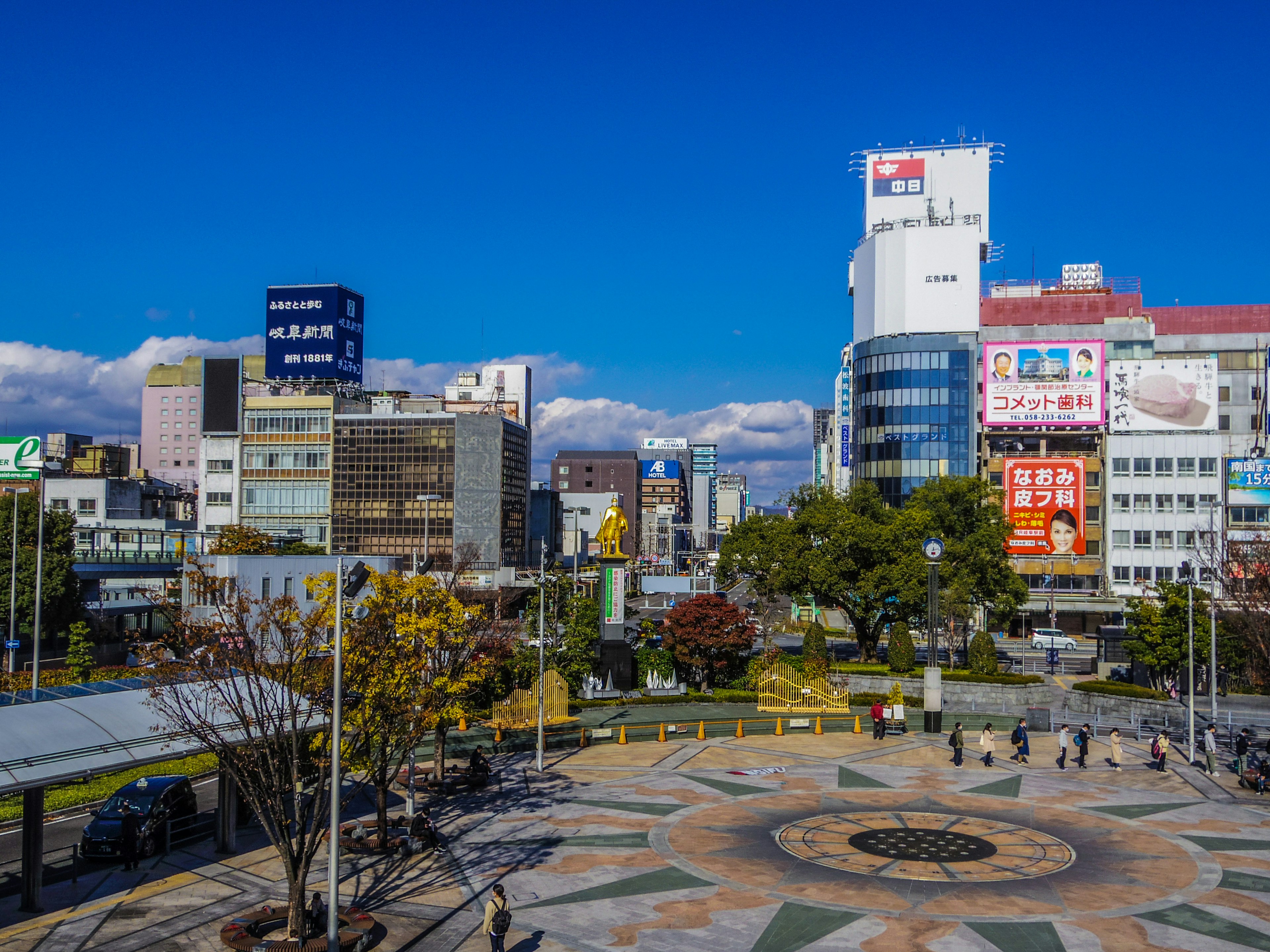 Urban square with high-rise buildings under a clear blue sky