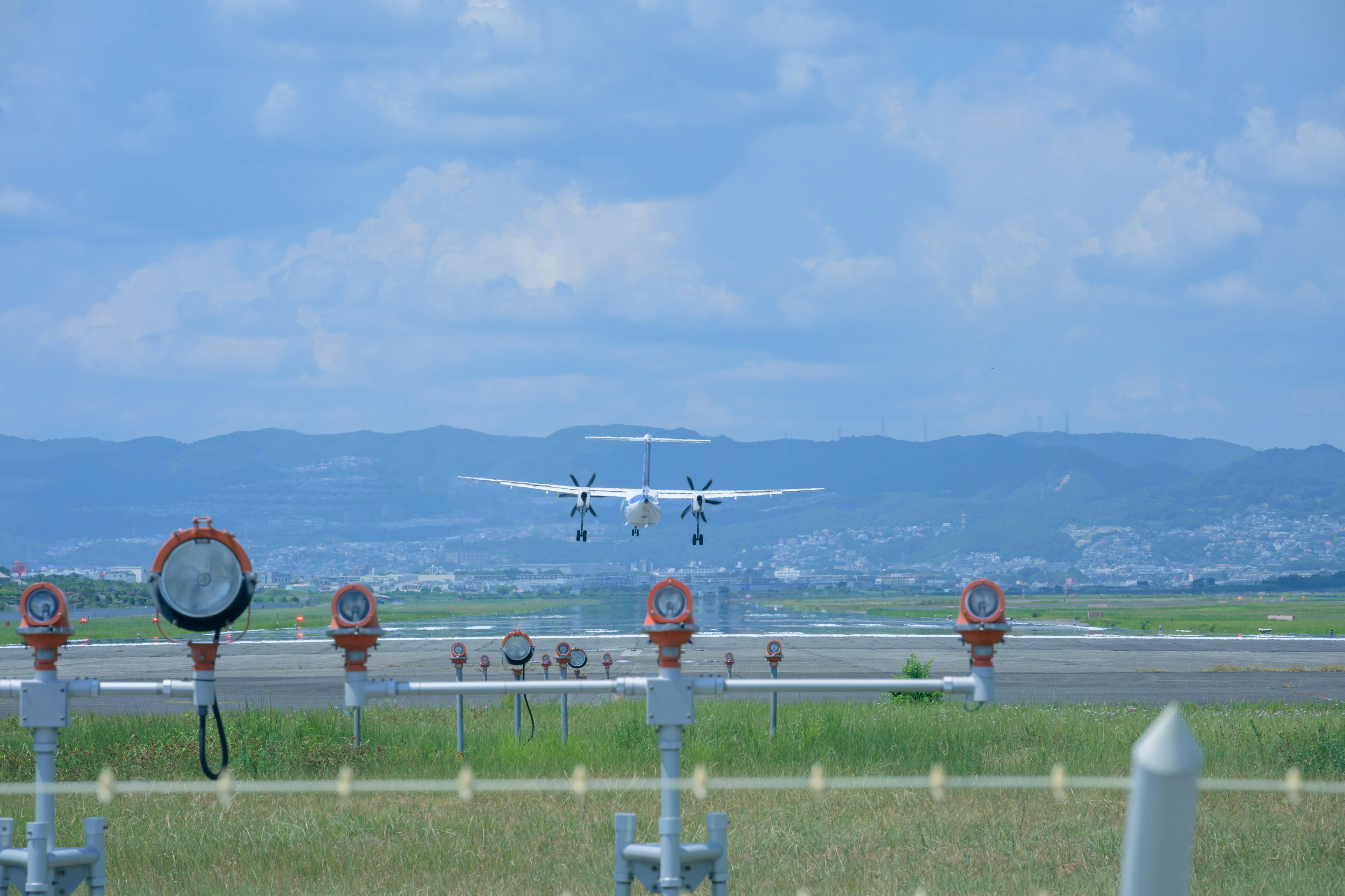 Aereo in atterraggio sulla pista con il paesaggio circostante