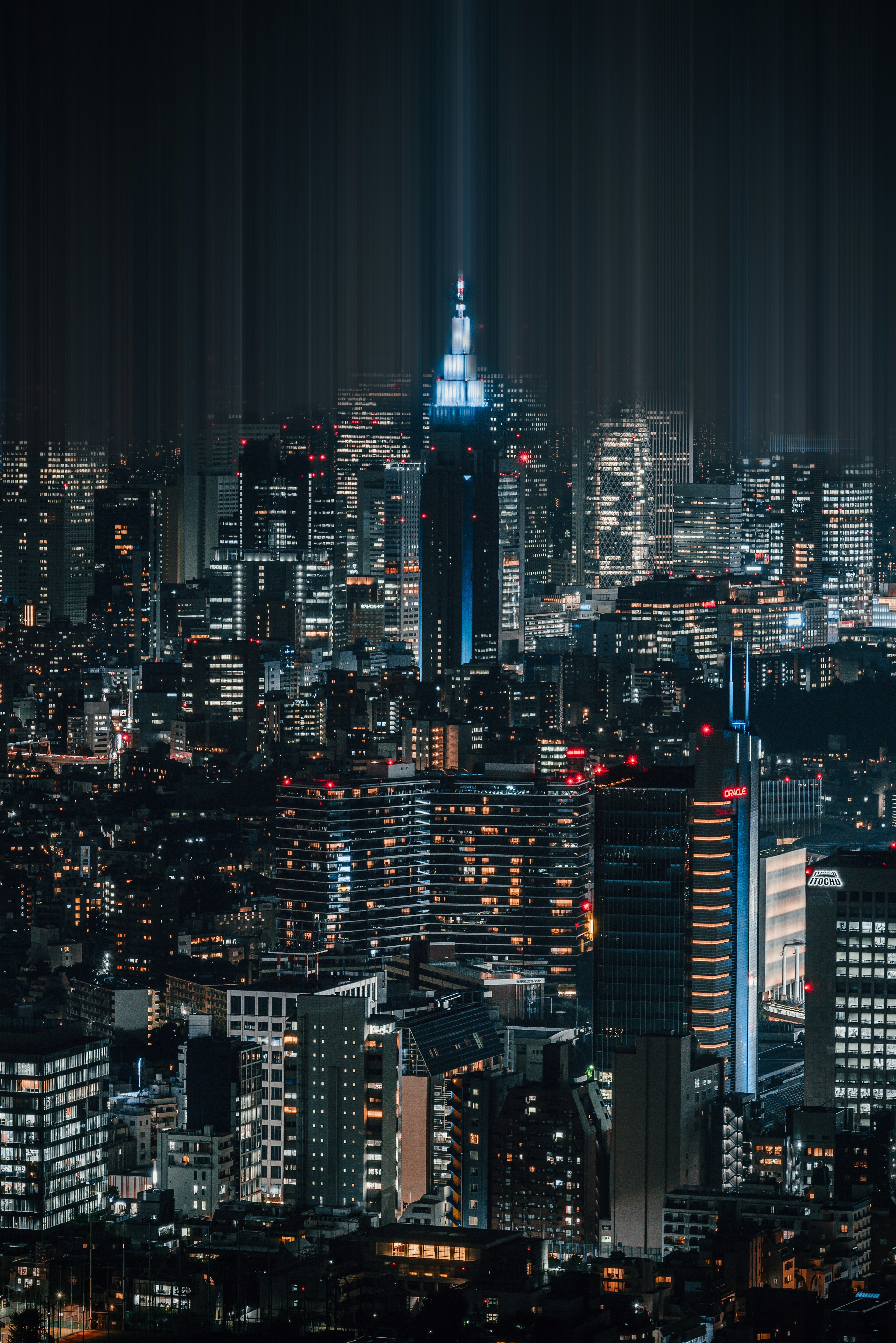 Stunning night view of Tokyo with skyscrapers illuminated bright lights highlighting a building resembling the Empire State Building