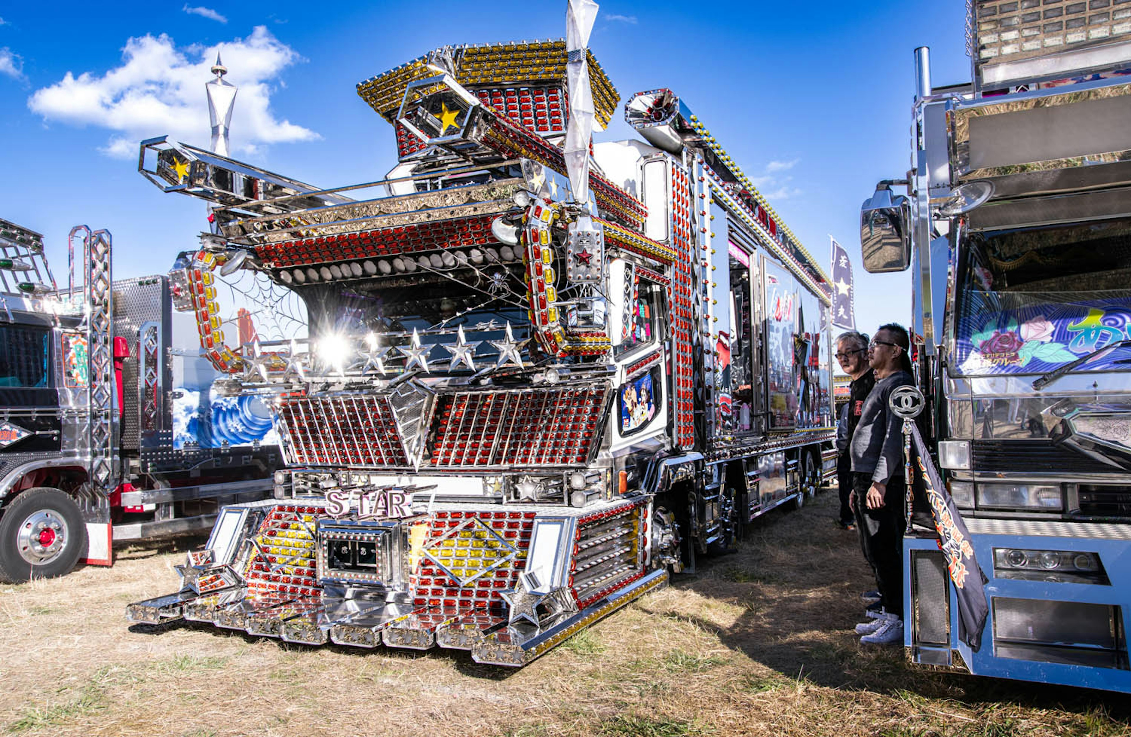 Decorated truck with intricate designs and people nearby