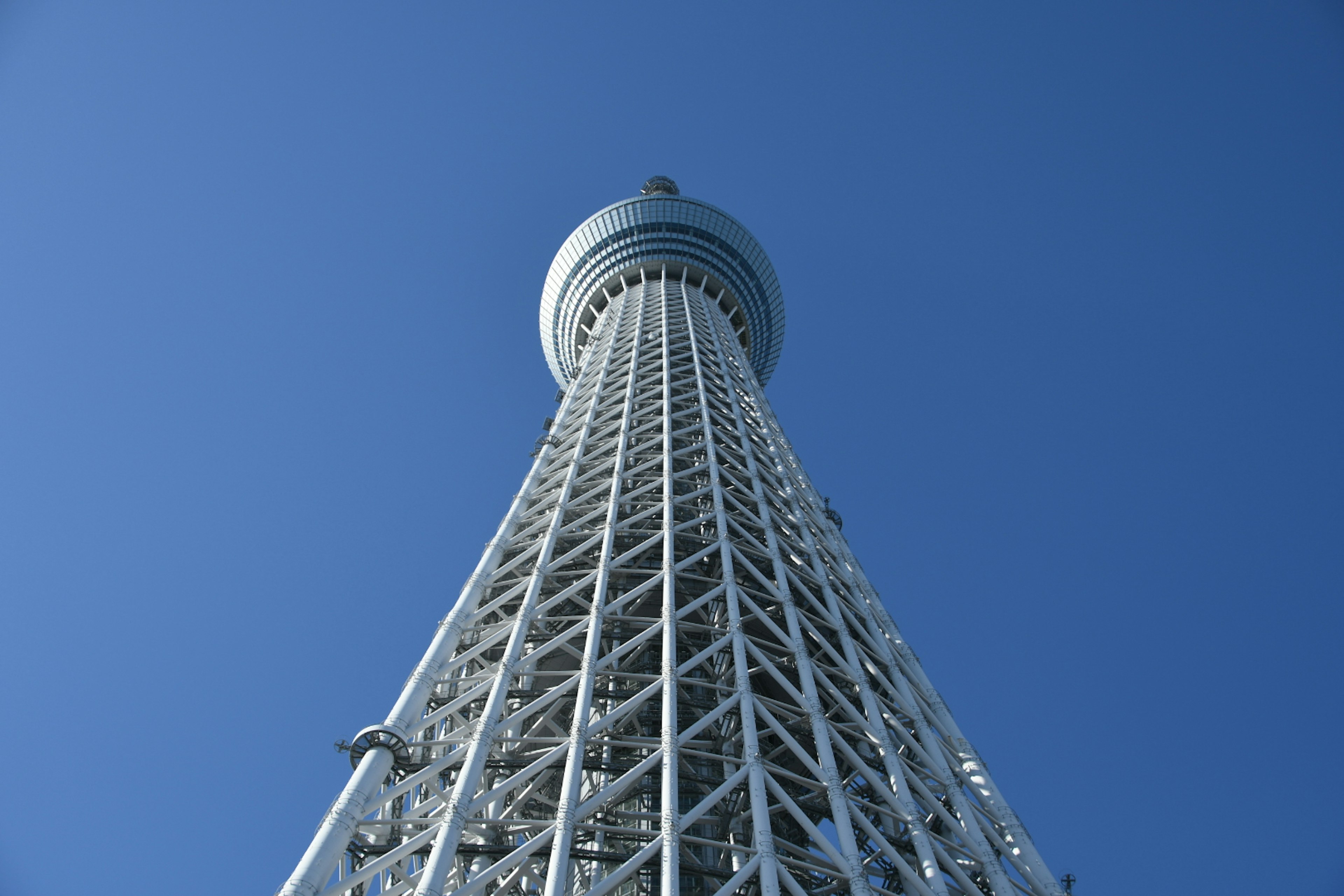 Pemandangan Tokyo Skytree dari bawah dengan latar belakang langit biru cerah