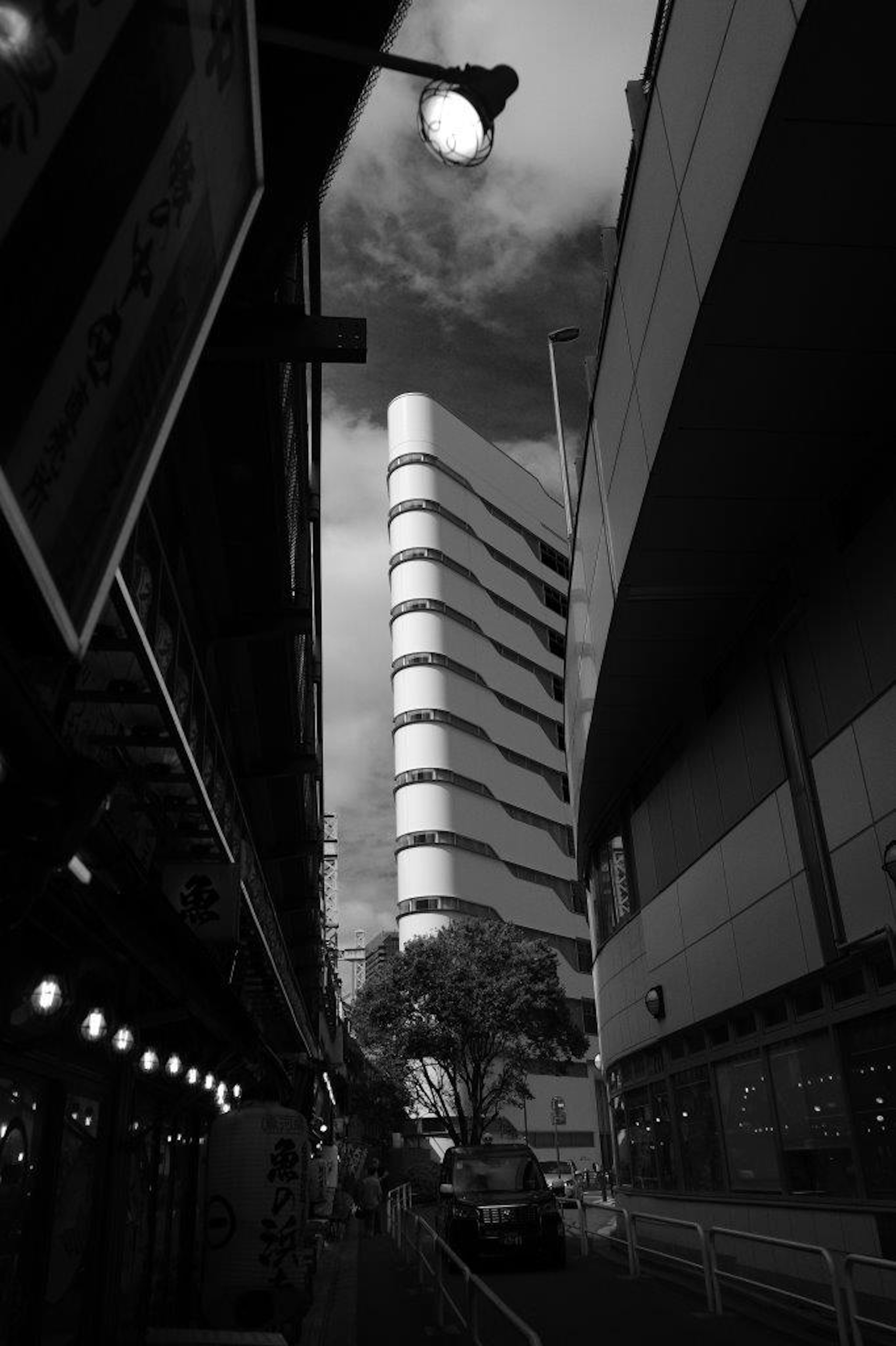 Edificio curvo único en un paisaje urbano en blanco y negro con estructuras circundantes