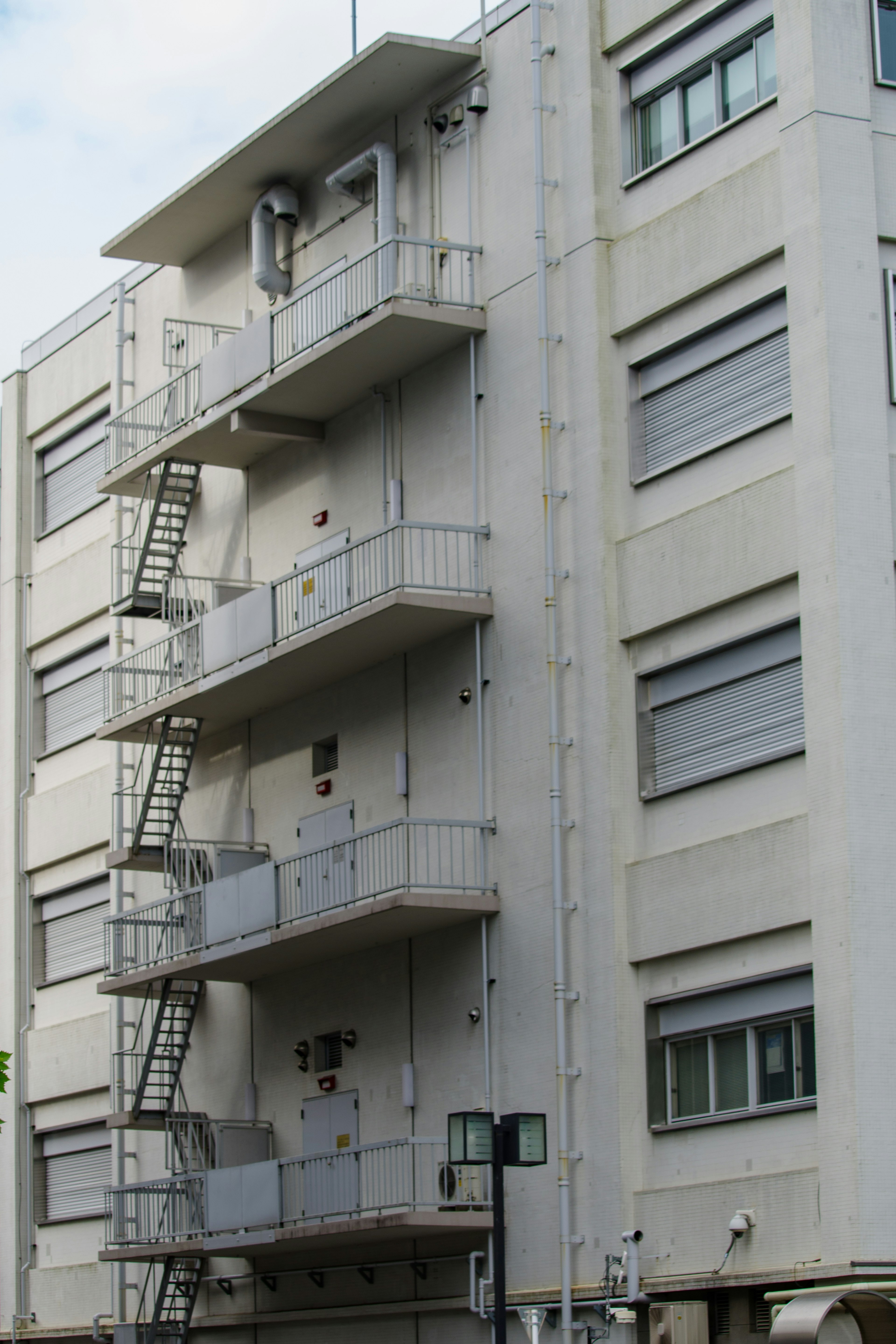 A building with white exterior and metal fire escape stairs