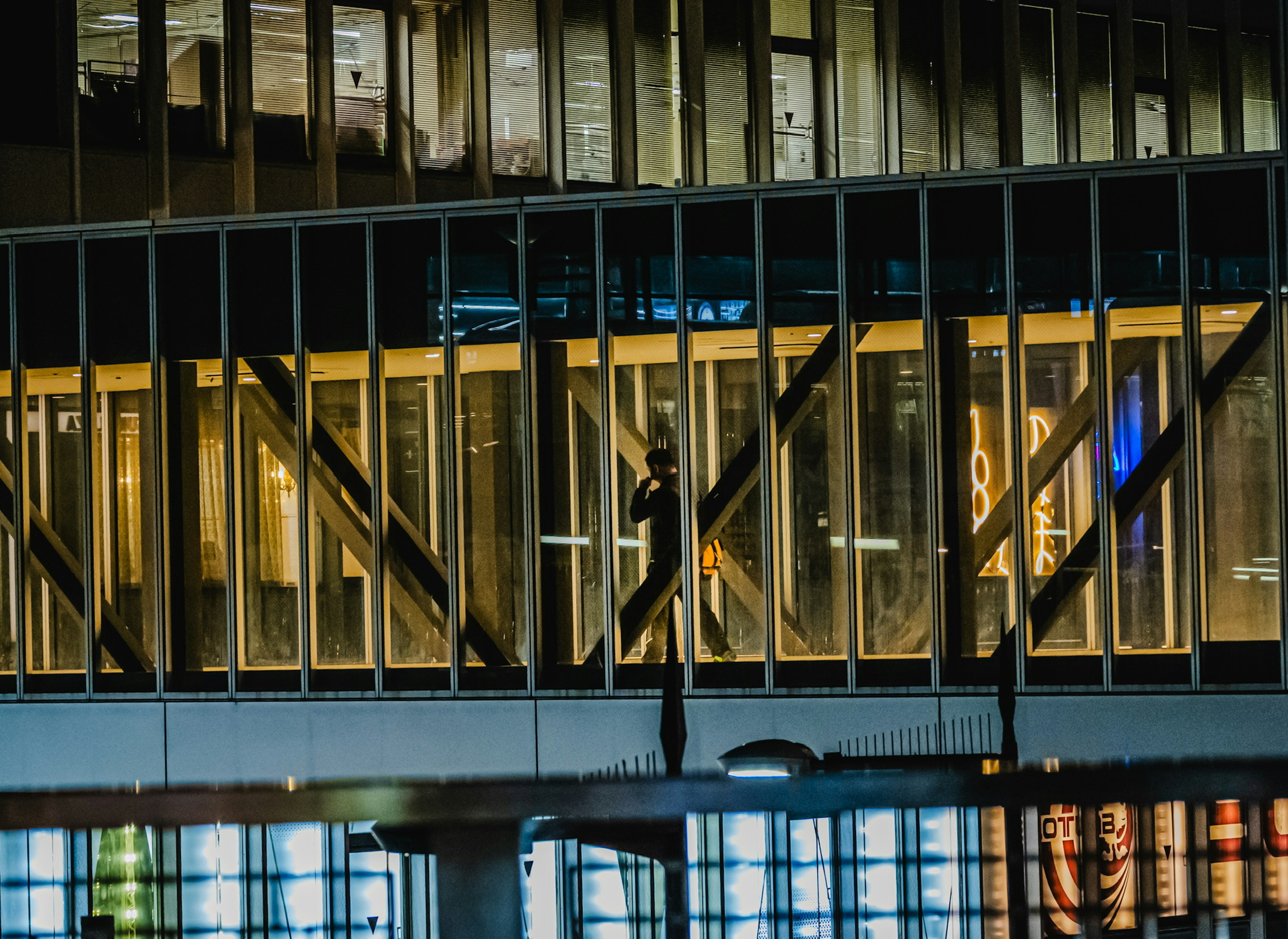 Silueta de una persona visible a través de las ventanas de un edificio por la noche