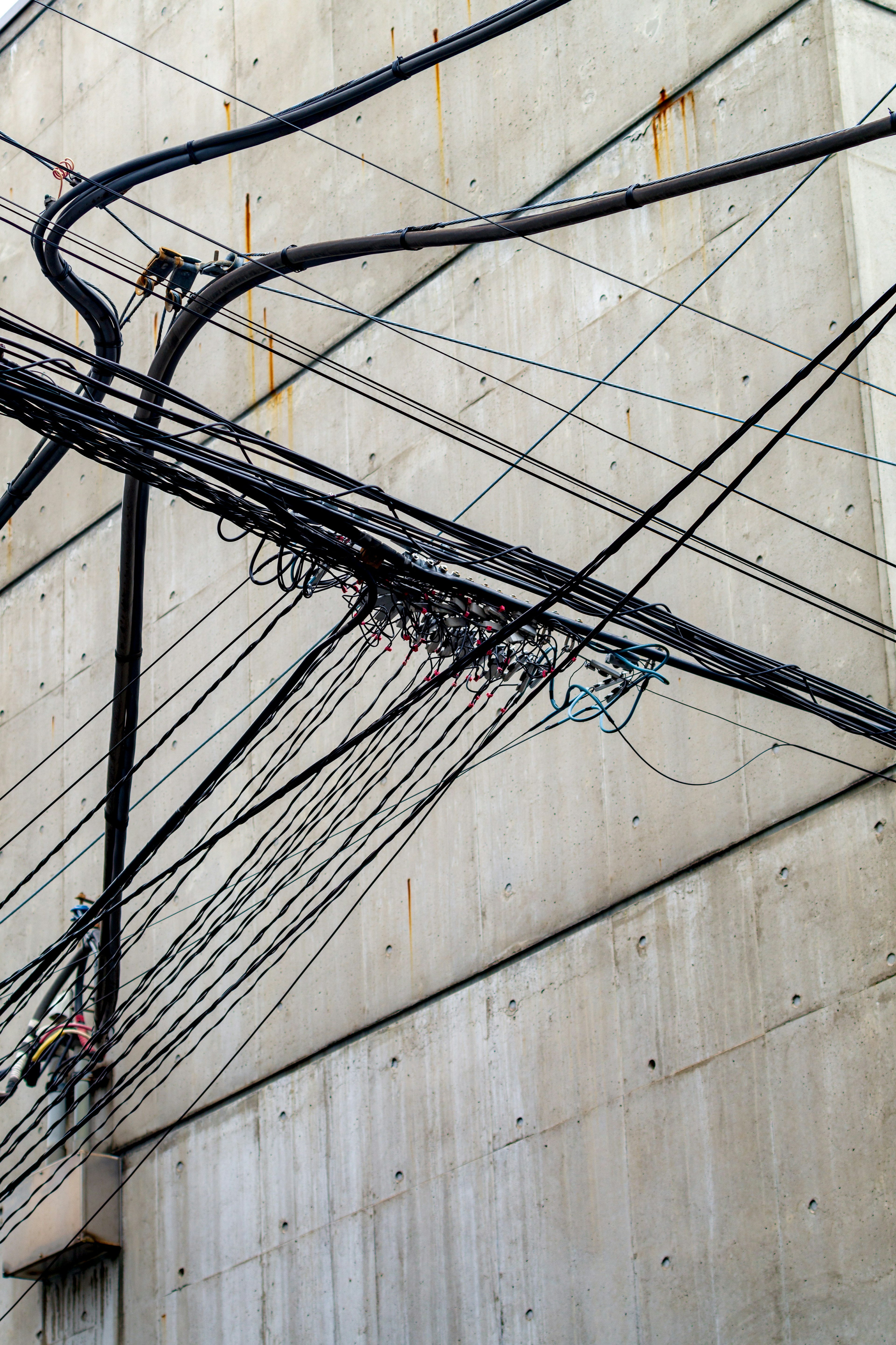 Image of tangled electrical wires against a concrete wall