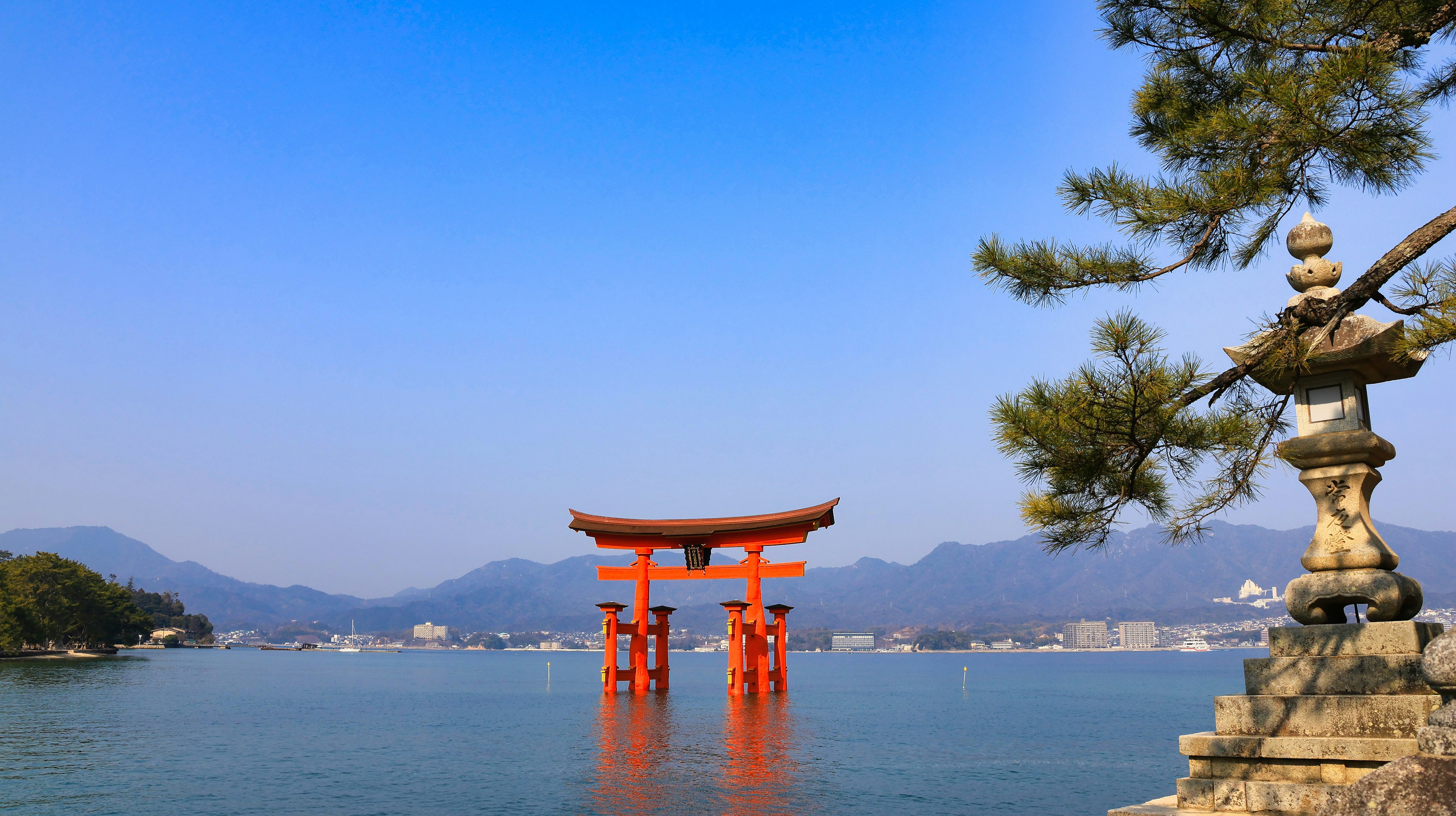 Torii rosso che galleggia sull'acqua con cielo blu