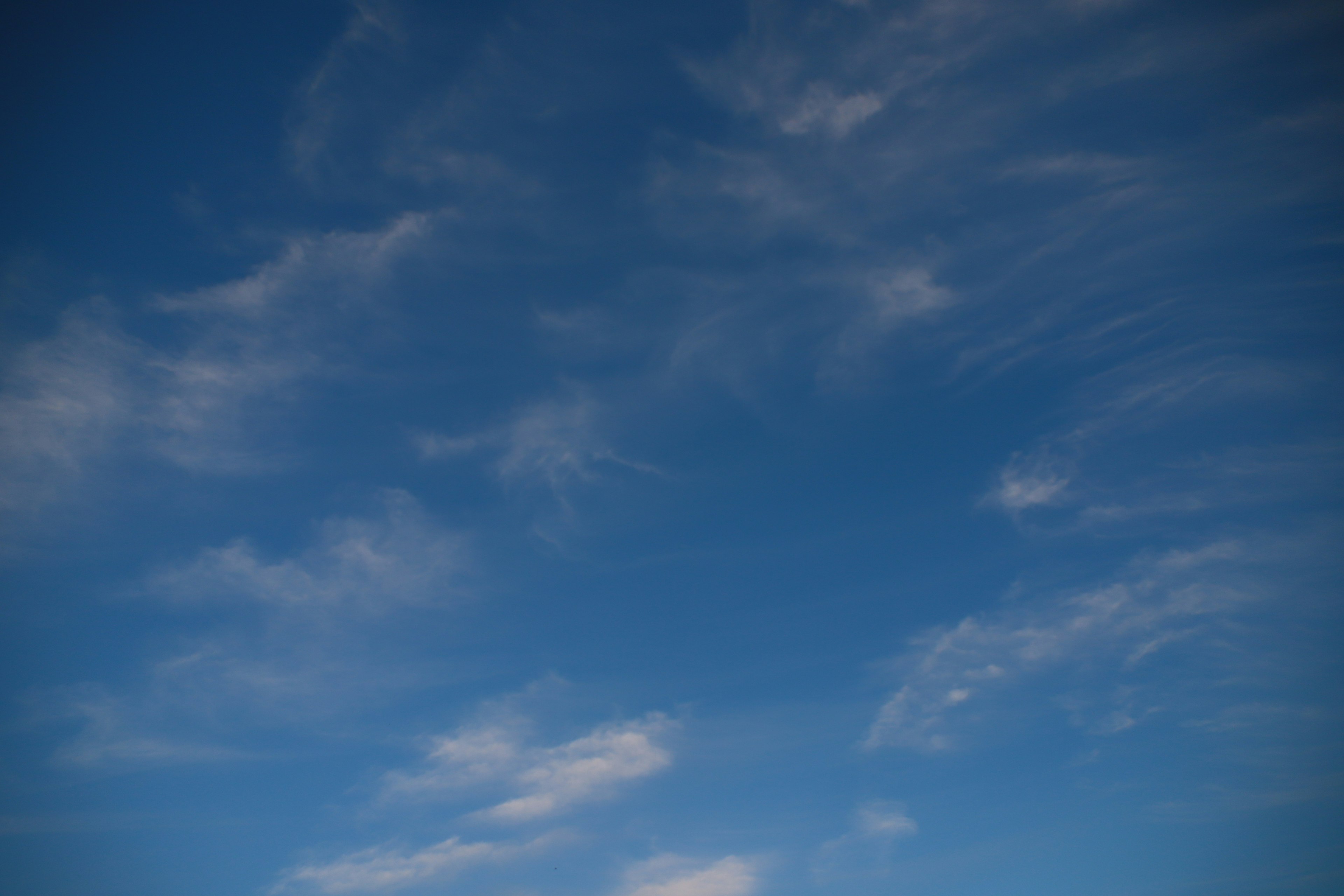 A blue sky with wispy clouds scattered throughout