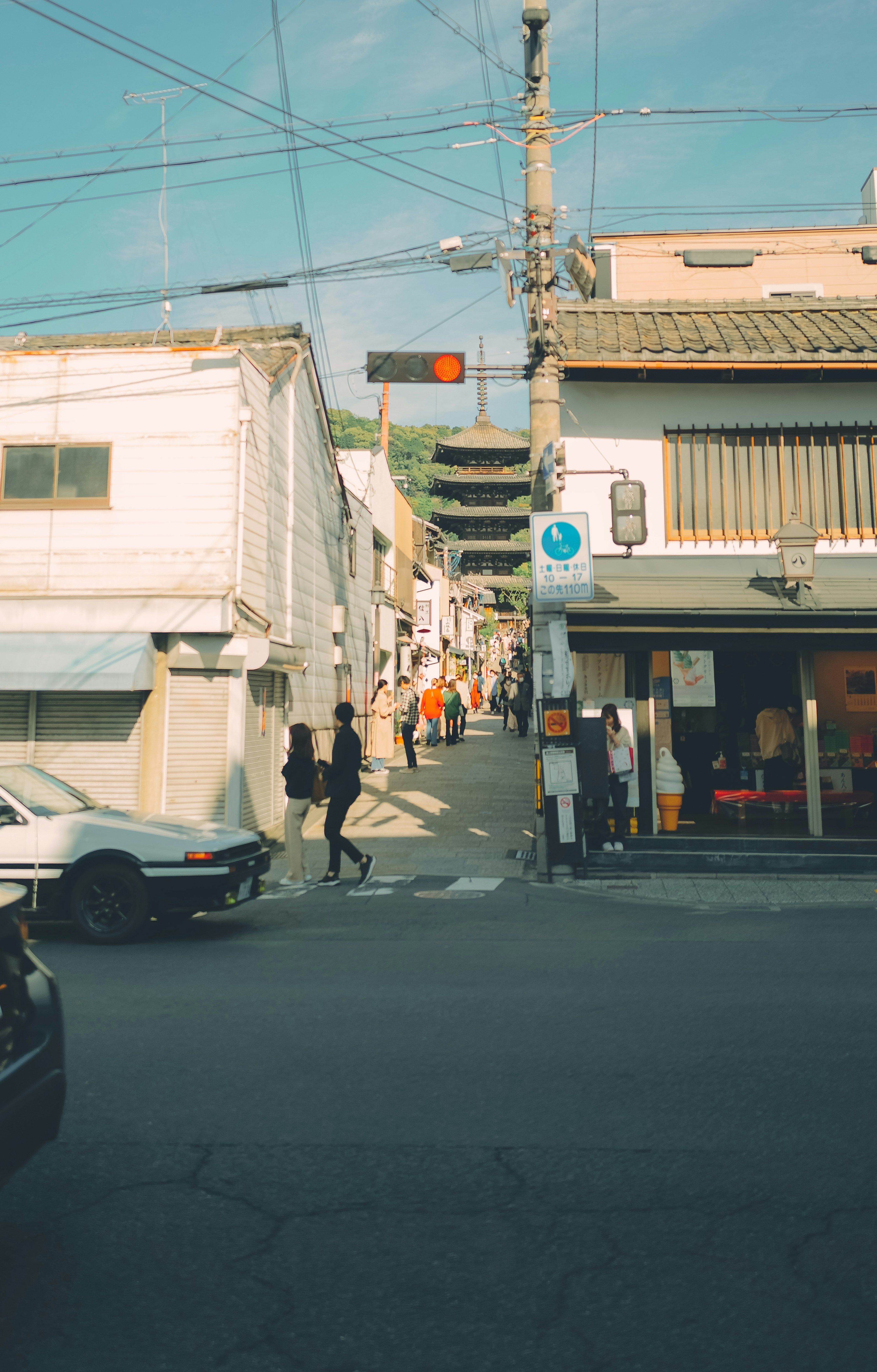 城市街景，有行人在白色建筑和商店附近