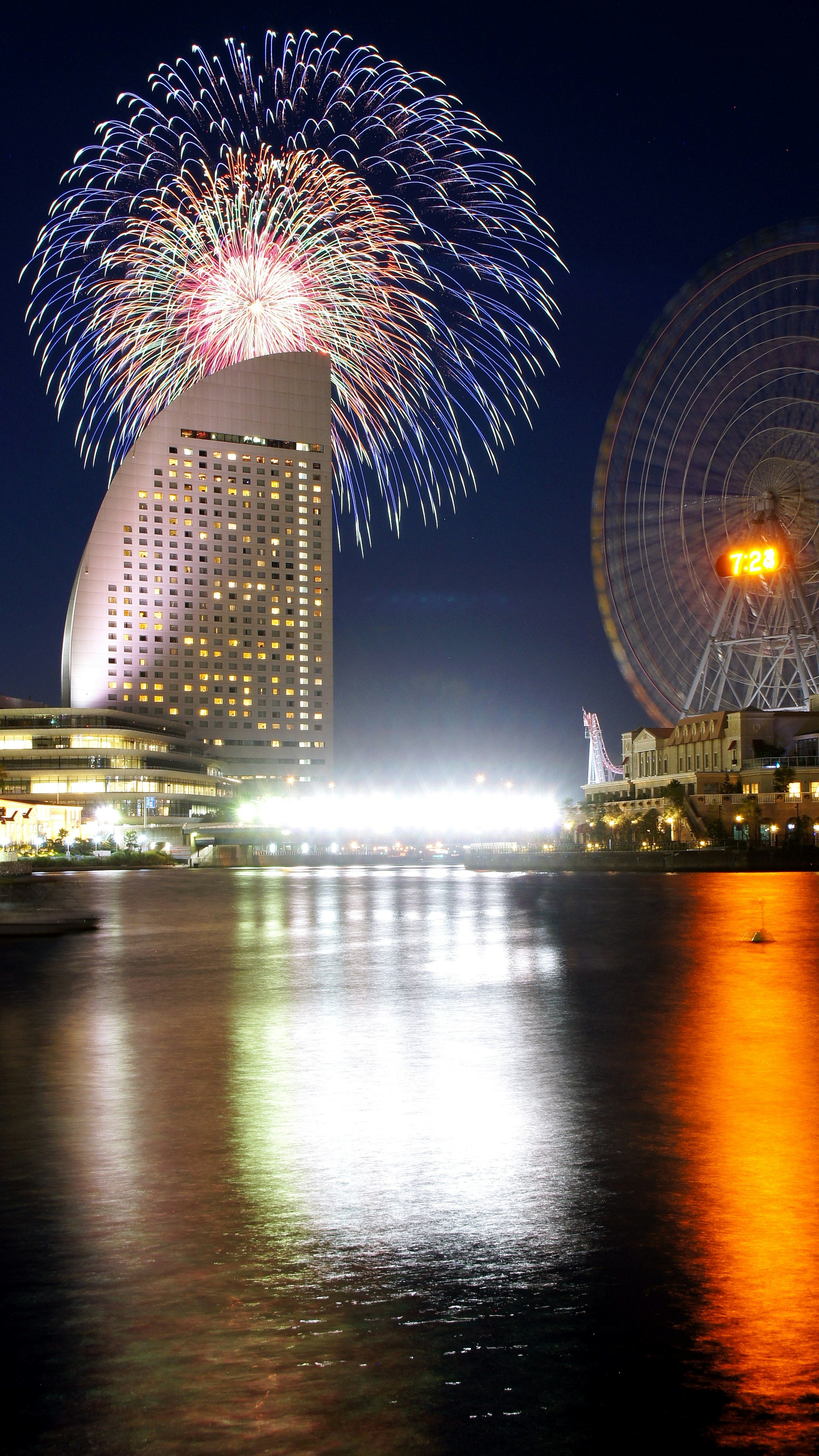 Des feux d'artifice illuminant la silhouette de Yokohama la nuit