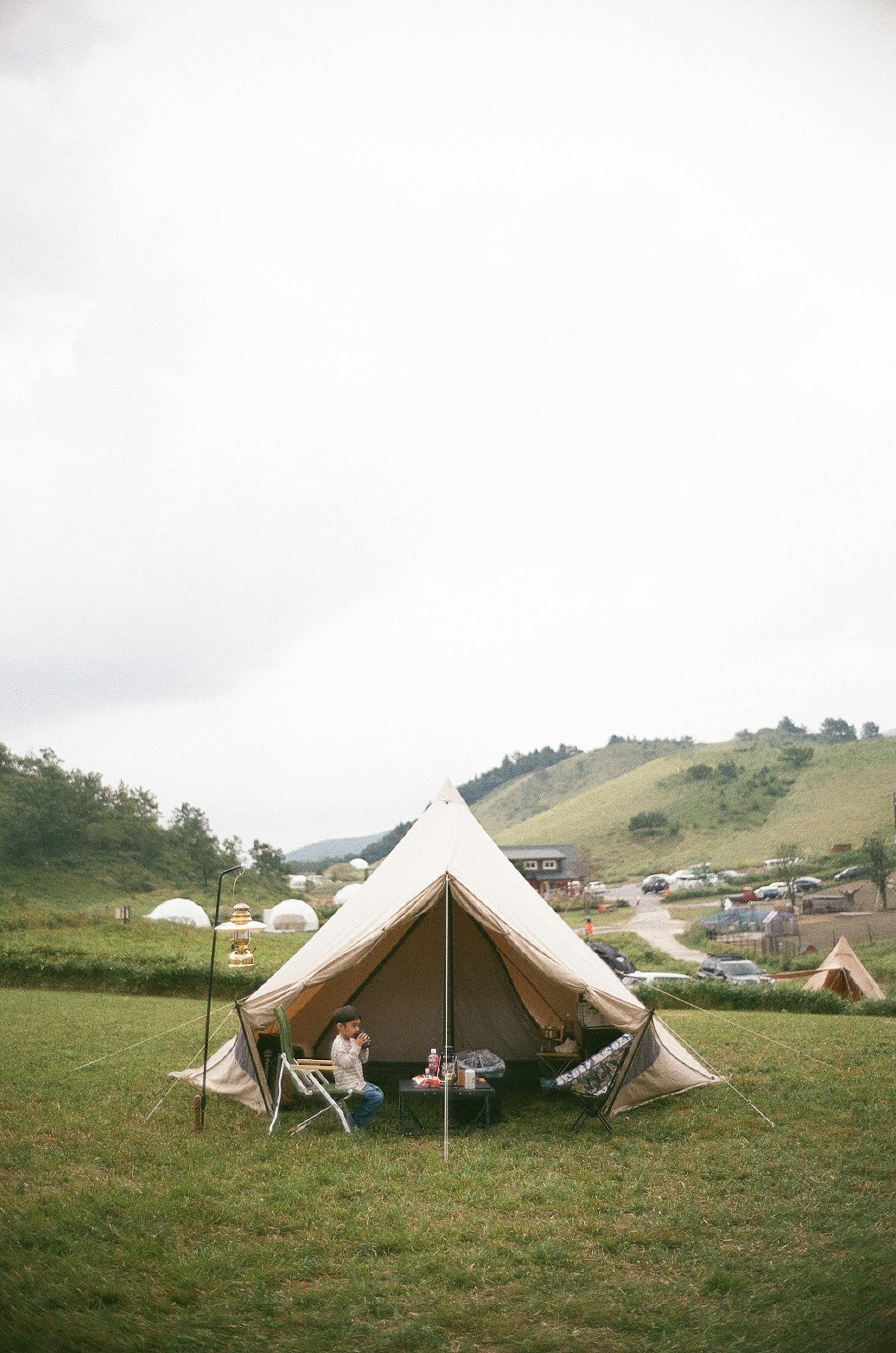 Grande tente sur une prairie verte avec une table et des chaises