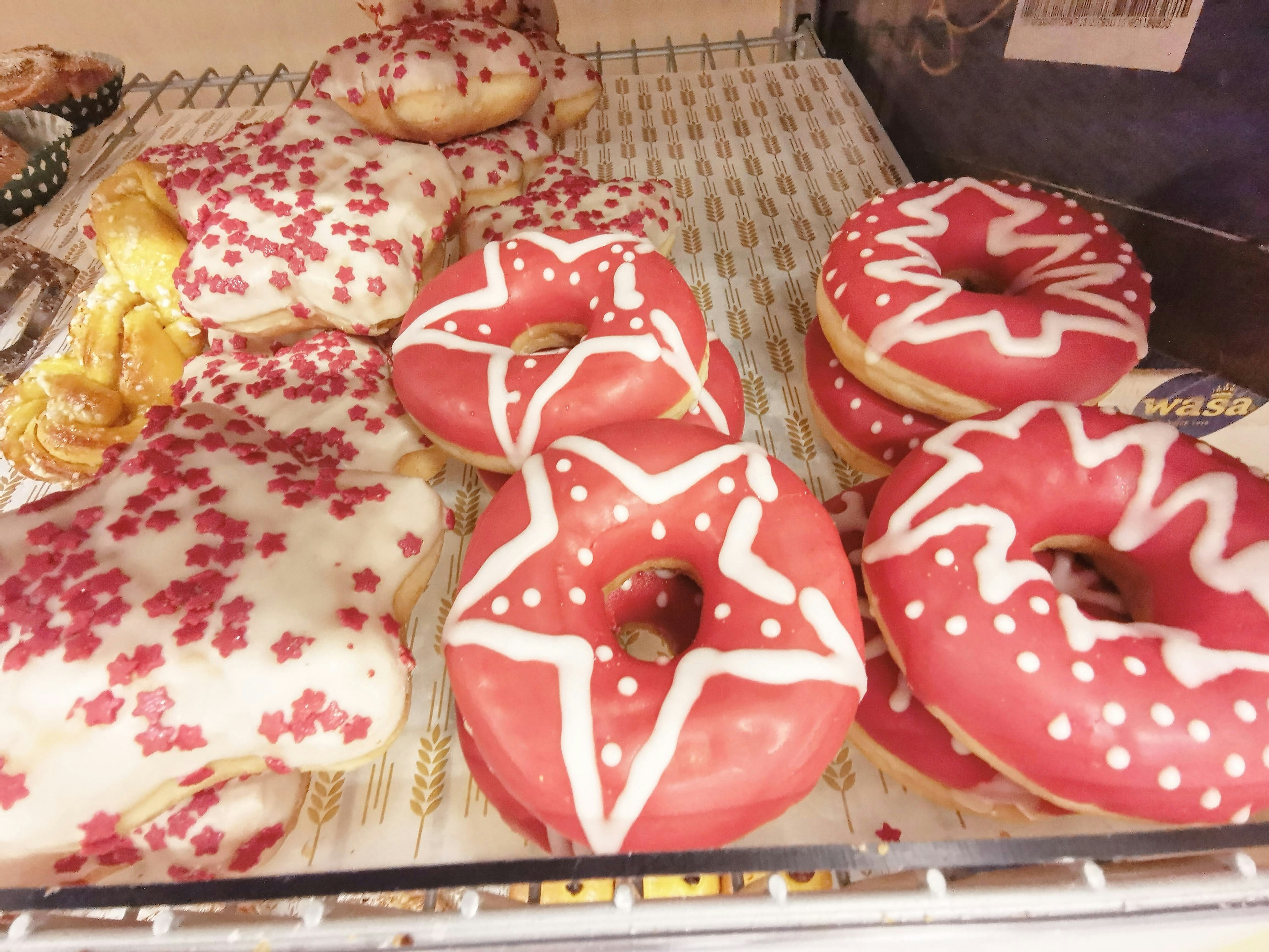 Auslage mit Donuts mit rotem und weißem Zuckerguss und sternförmigen Gebäck