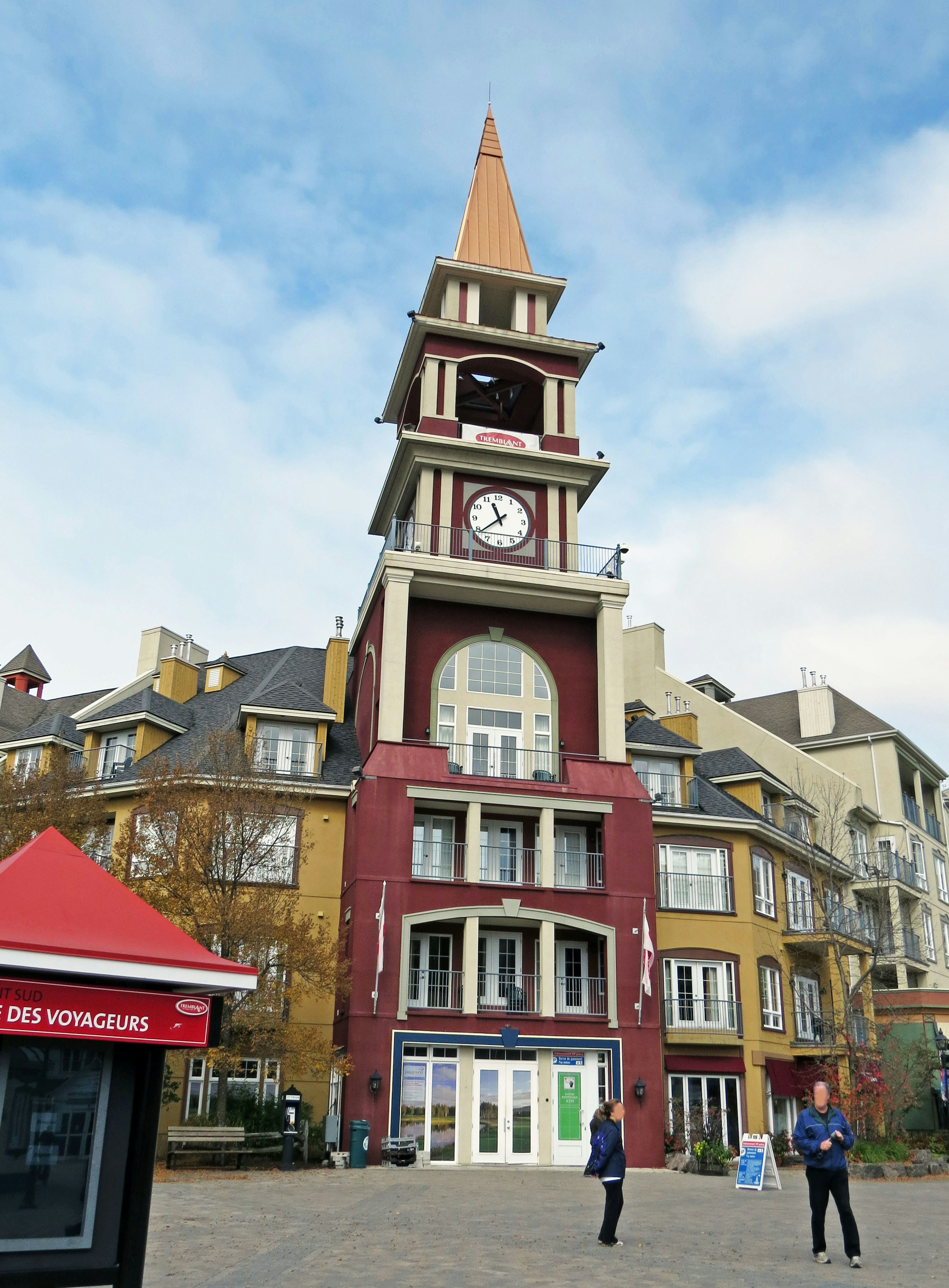 Vista escénica de una torre reloj y edificios coloridos en una plaza