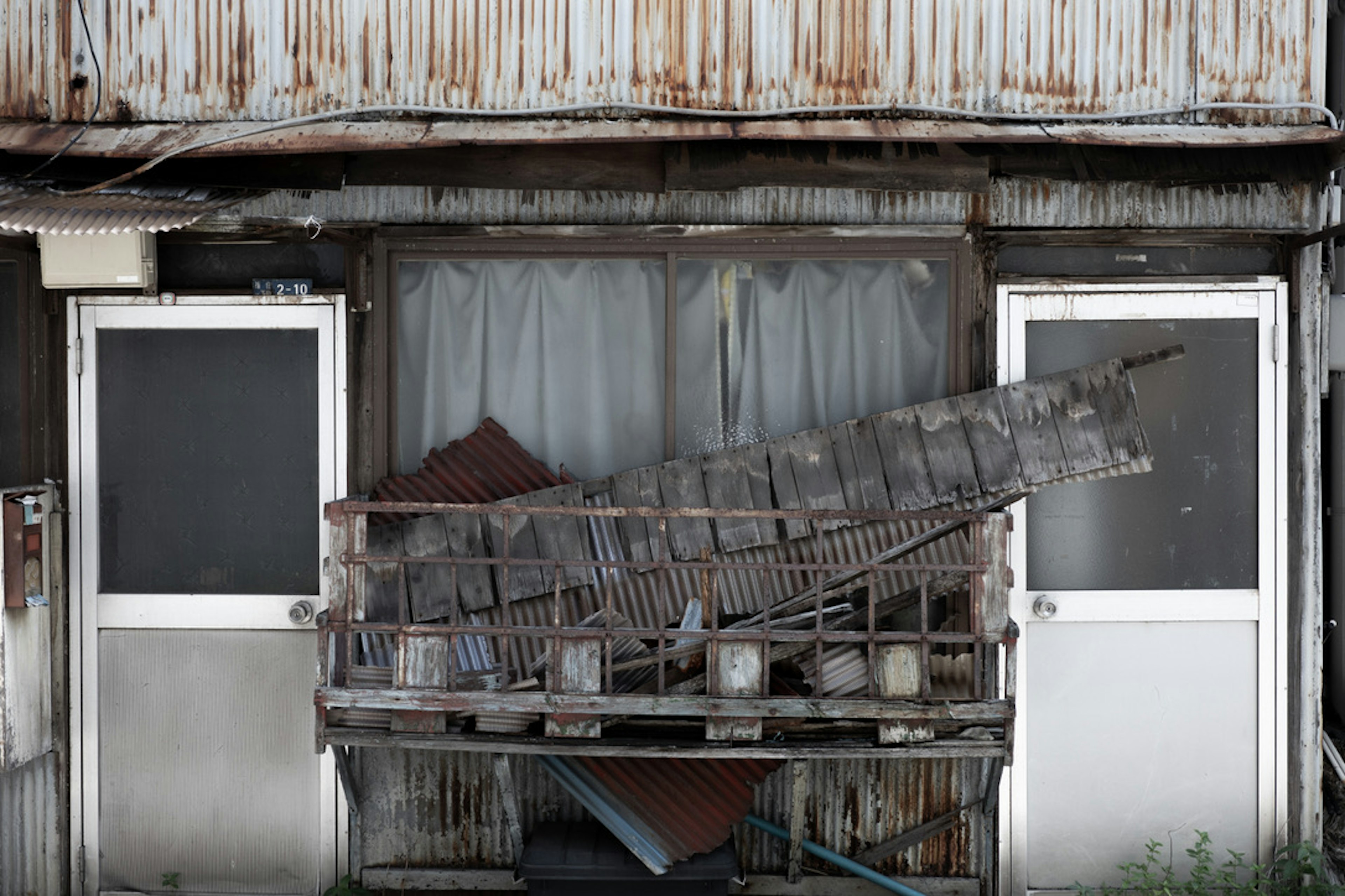 Palette en bois et fenêtre brisée devant un vieux bâtiment