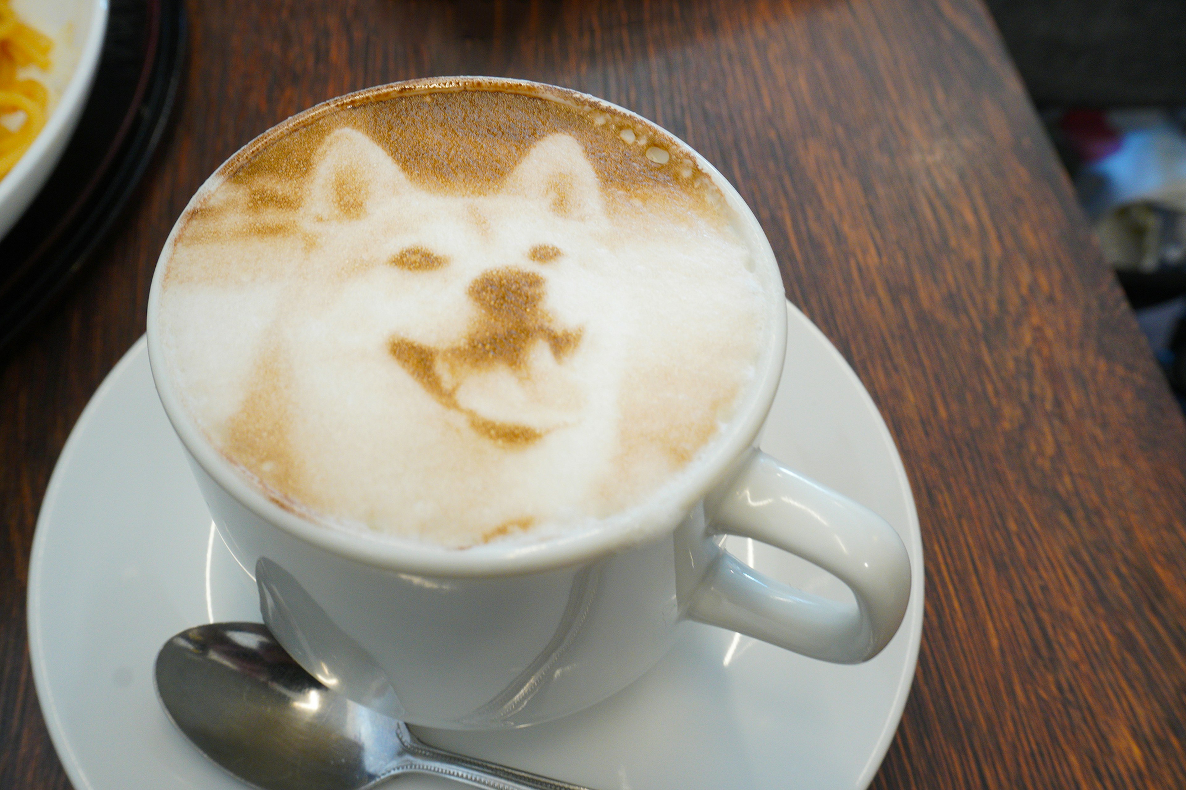 Cangkir kopi dengan desain latte art anjing