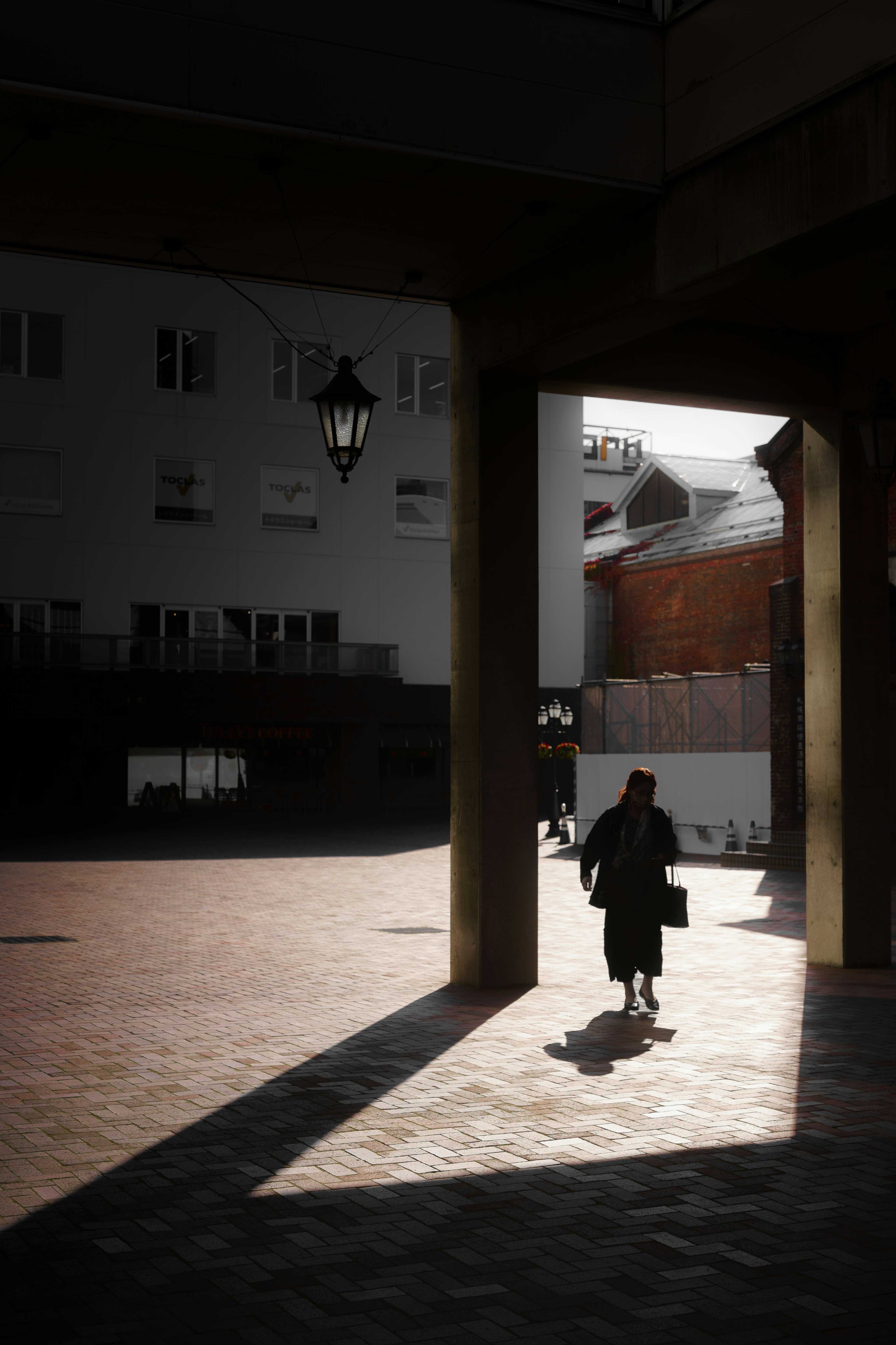 Silueta de una persona caminando bajo un arco Contraste de luz y sombra