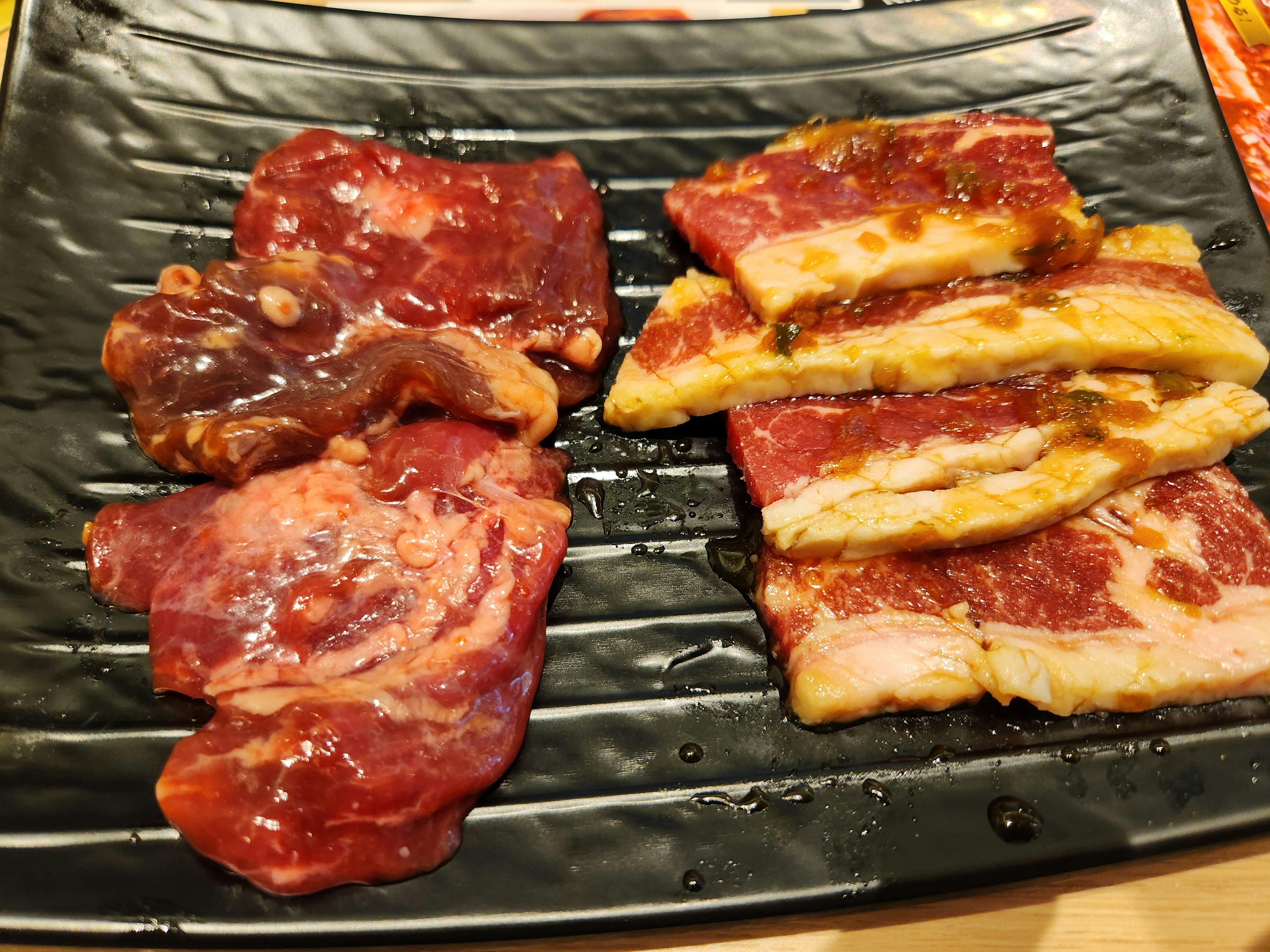 A plate of deliciously marbled meat slices for grilling