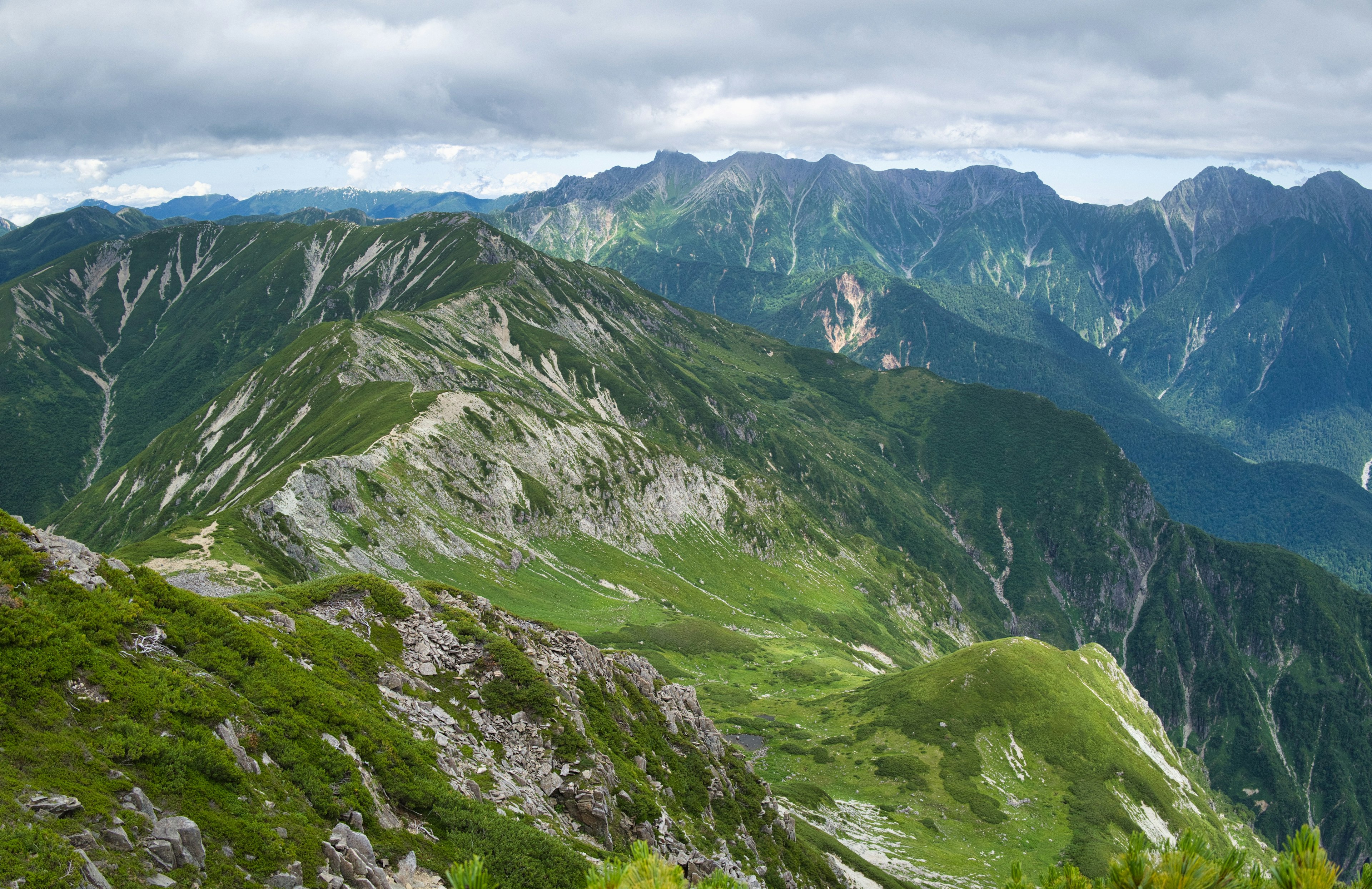 Vue panoramique de montagnes verdoyantes et de terrains rocheux escarpés