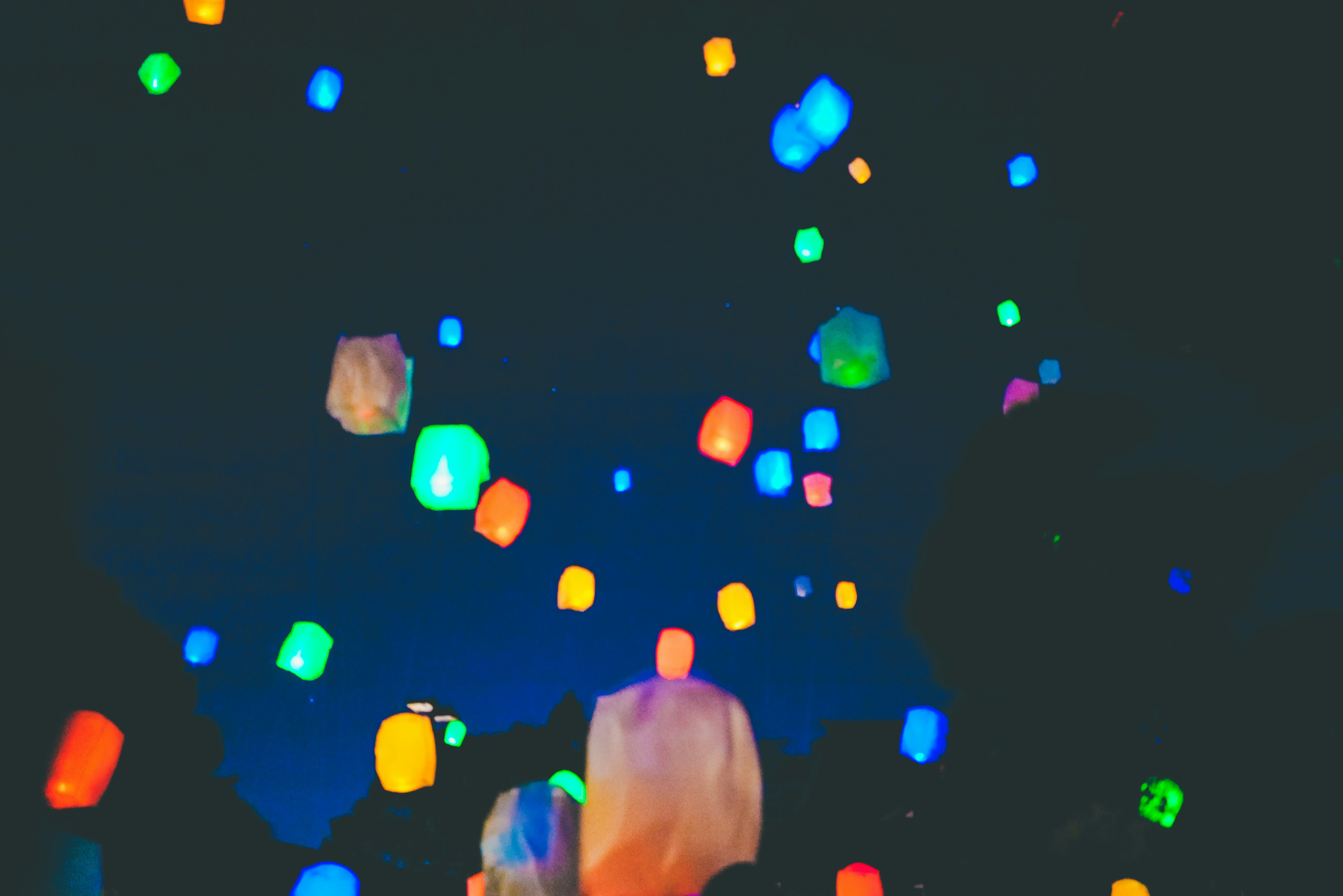 Des lanternes colorées flottant dans le ciel nocturne