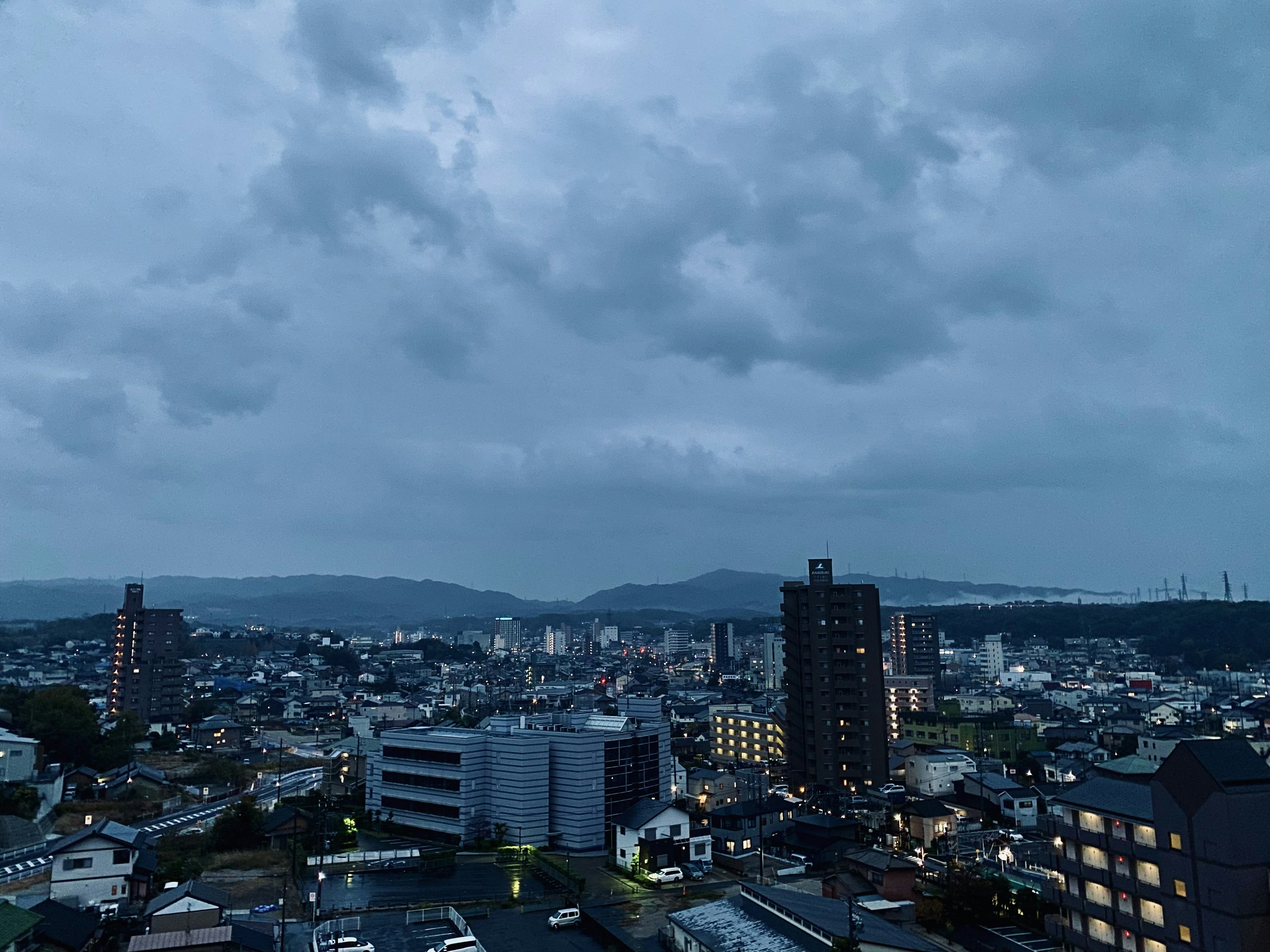 Night cityscape with cloudy sky buildings illuminated