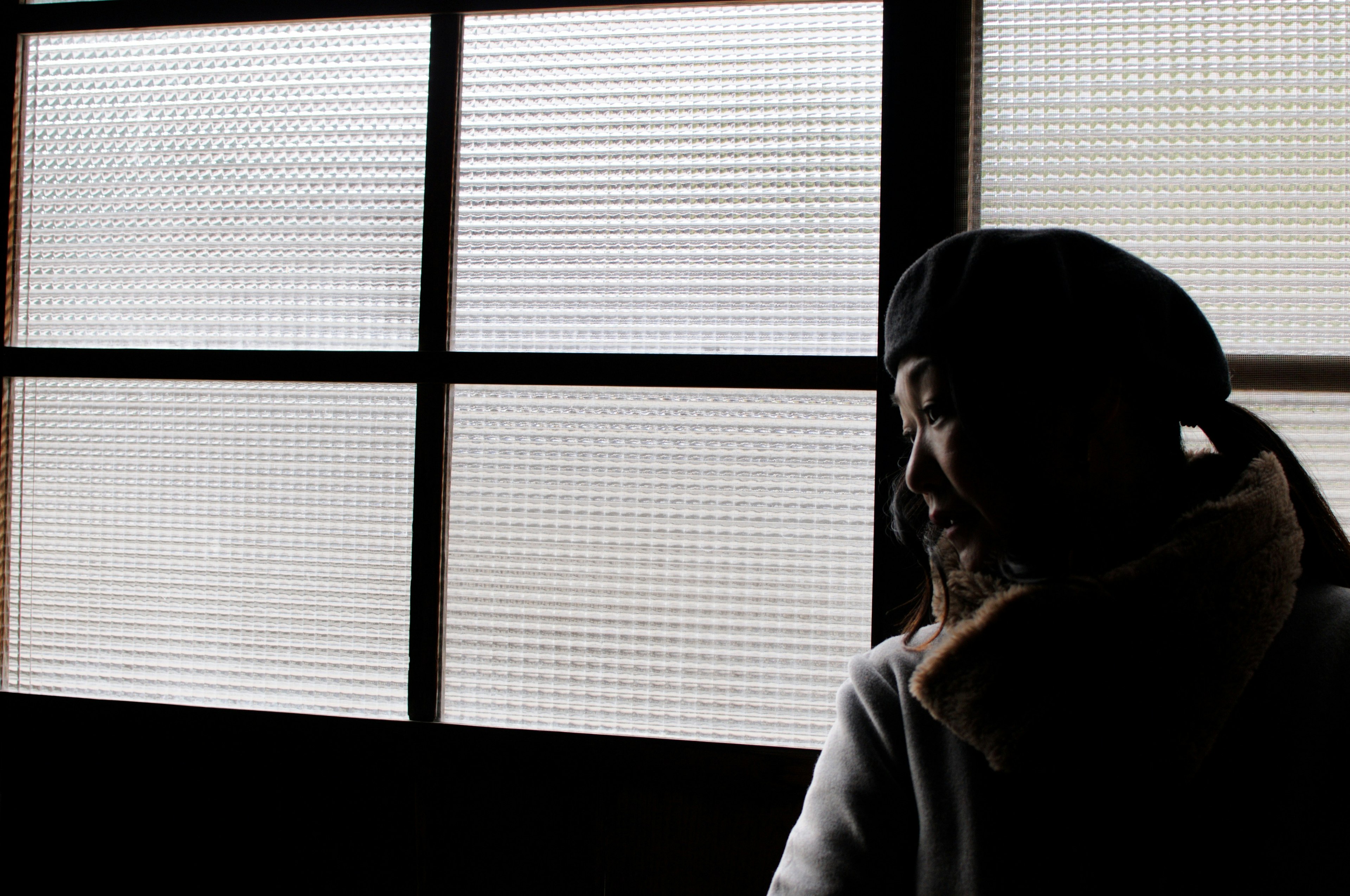 Silhouette of a person standing in front of a window in a room