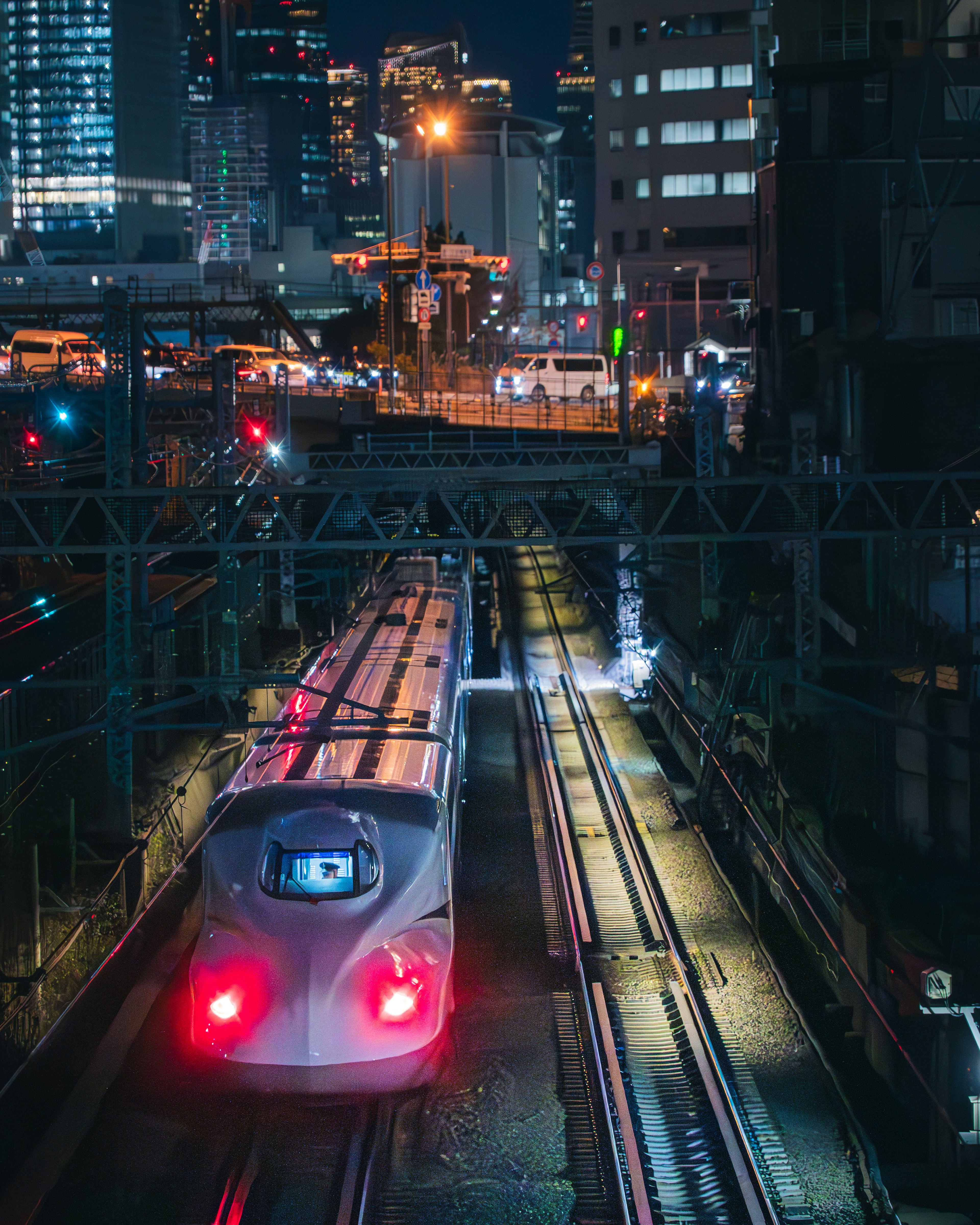 Gambar kereta Shinkansen yang berjalan di kota pada malam hari