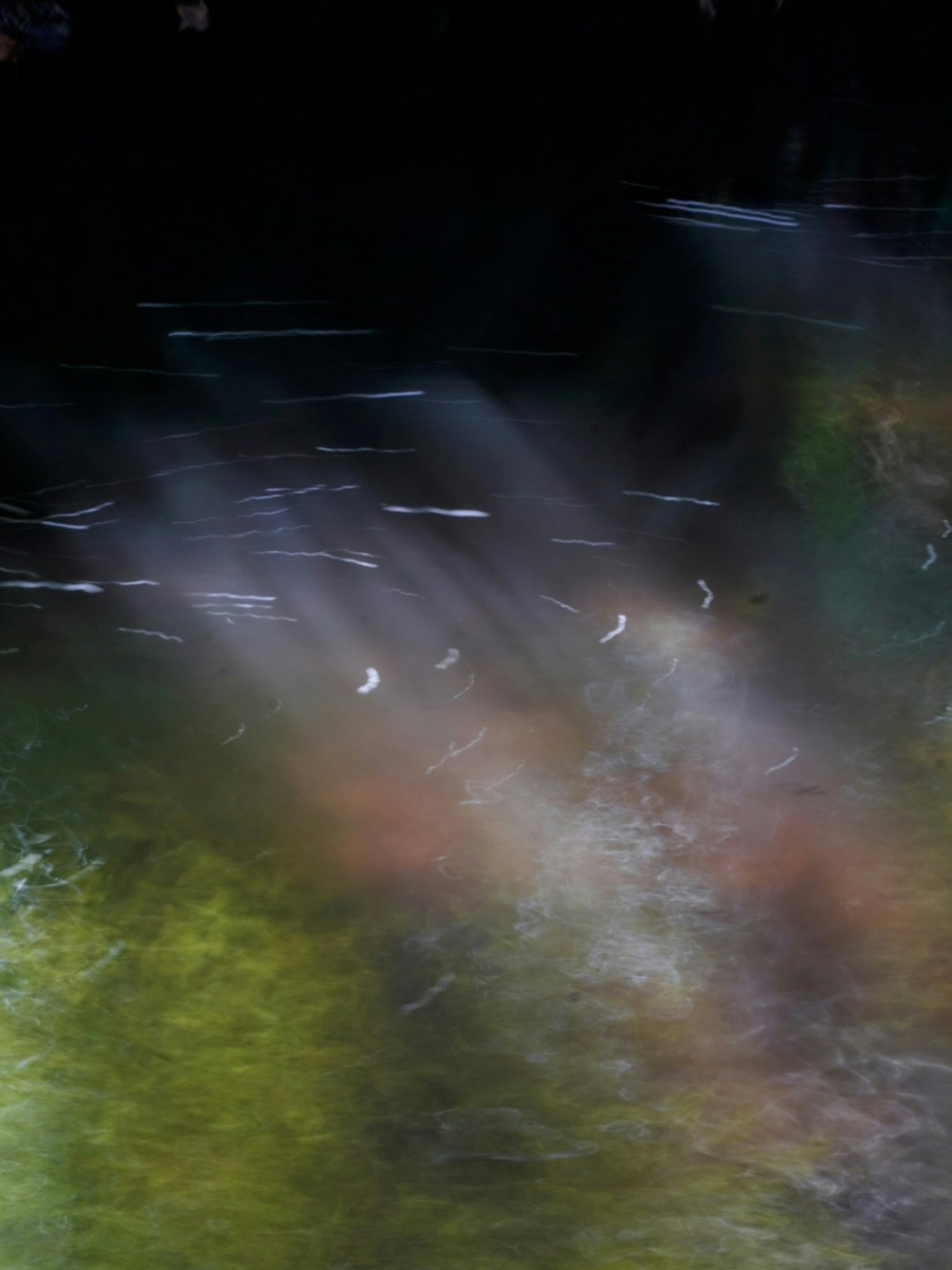 Abstract landscape featuring light beams and color variations on the water surface