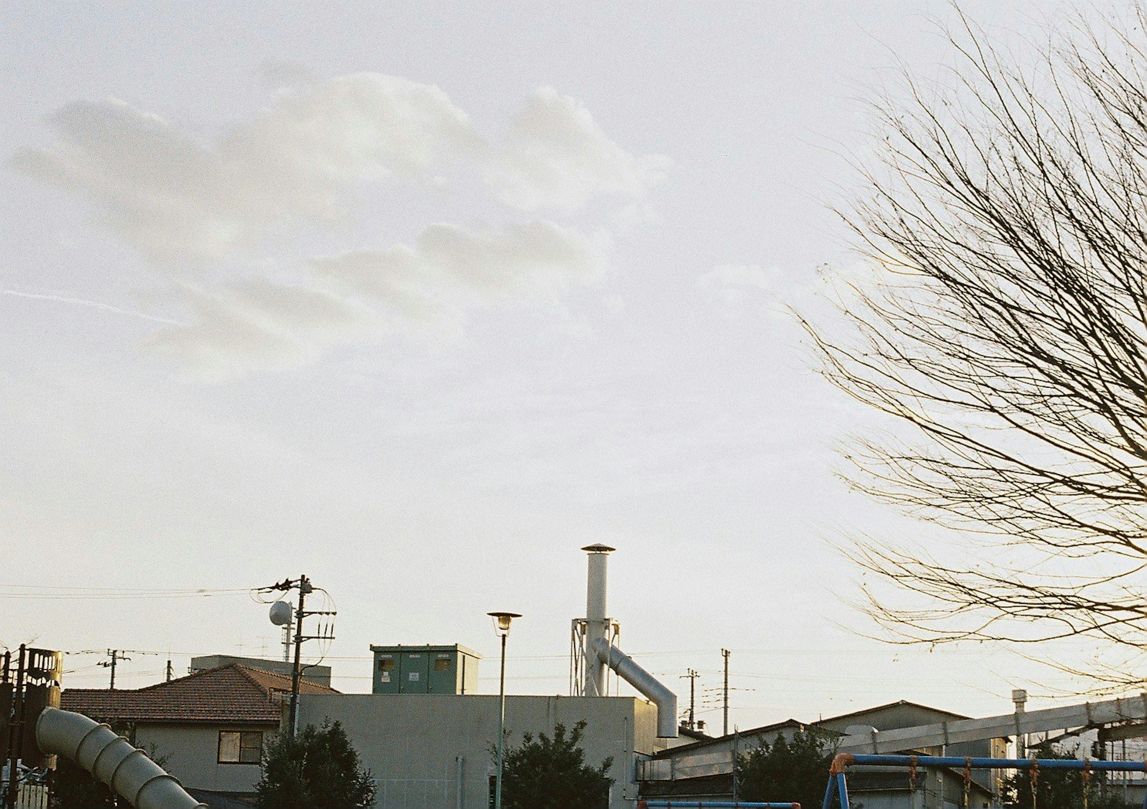 Landscape featuring a factory chimney and silhouette of a tree