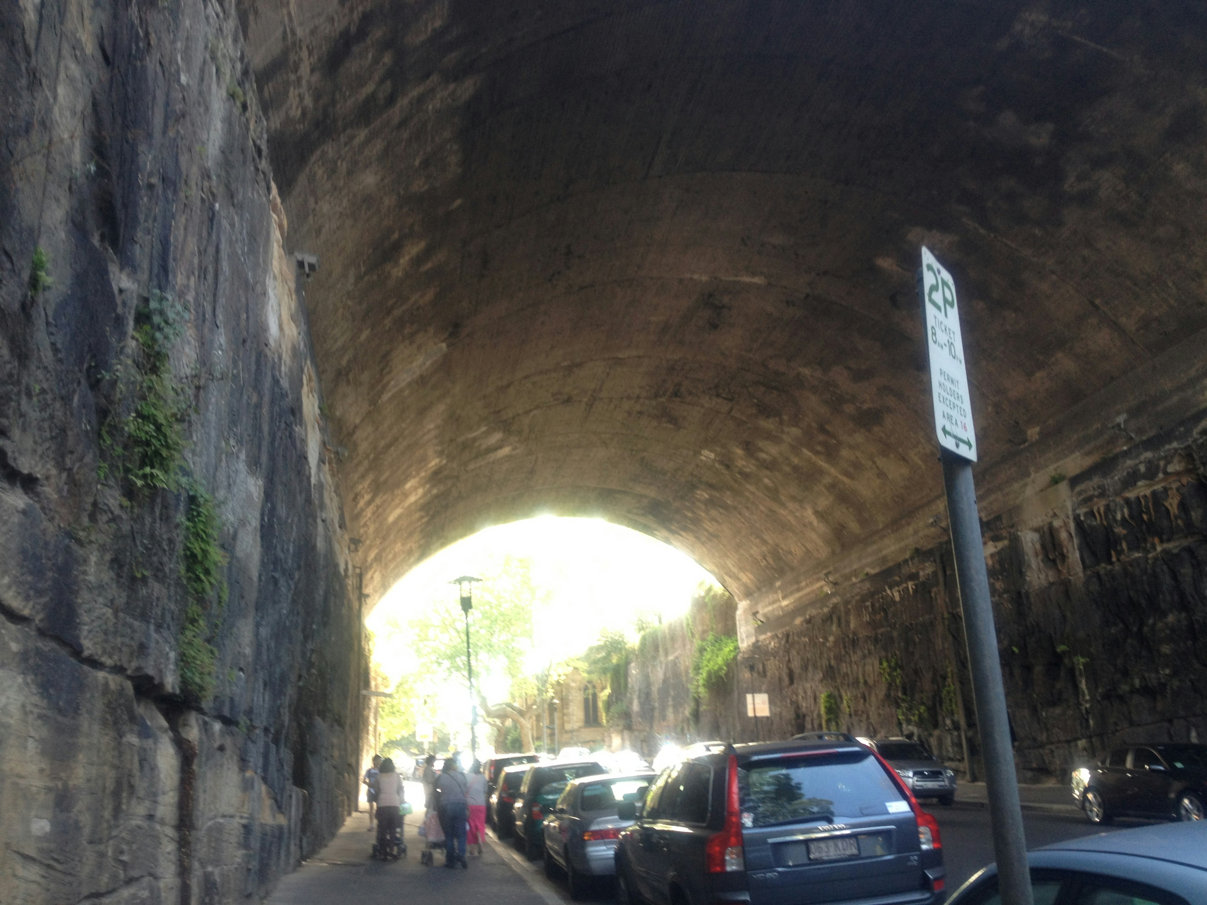 Imagen que muestra coches y personas dentro de un túnel con una apertura brillante