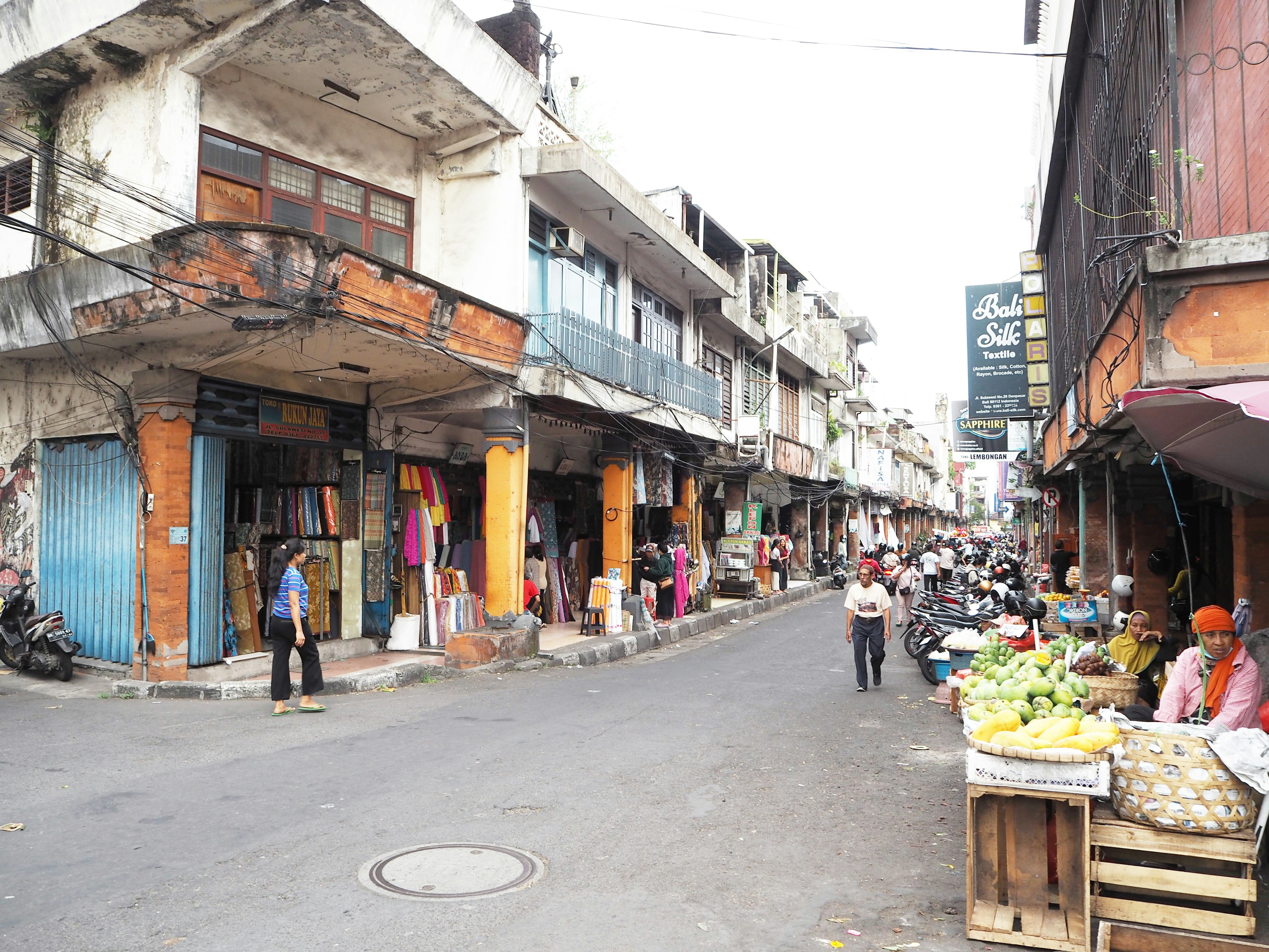 ตลาดริมถนนที่คึกคักมีร้านค้าเก่าเรียงรายอยู่