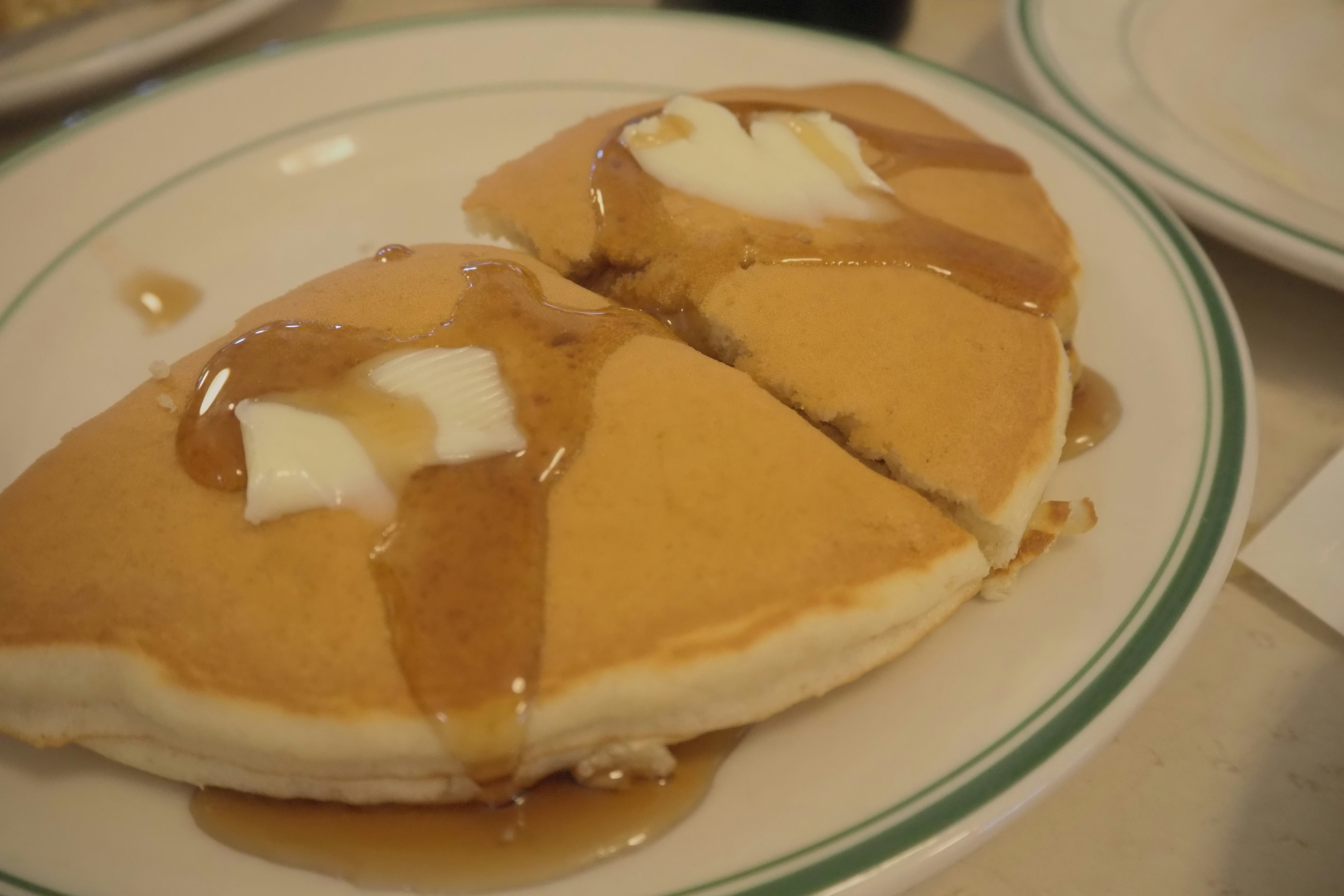 Teller mit Pfannkuchen, belegt mit Butter und Sirup