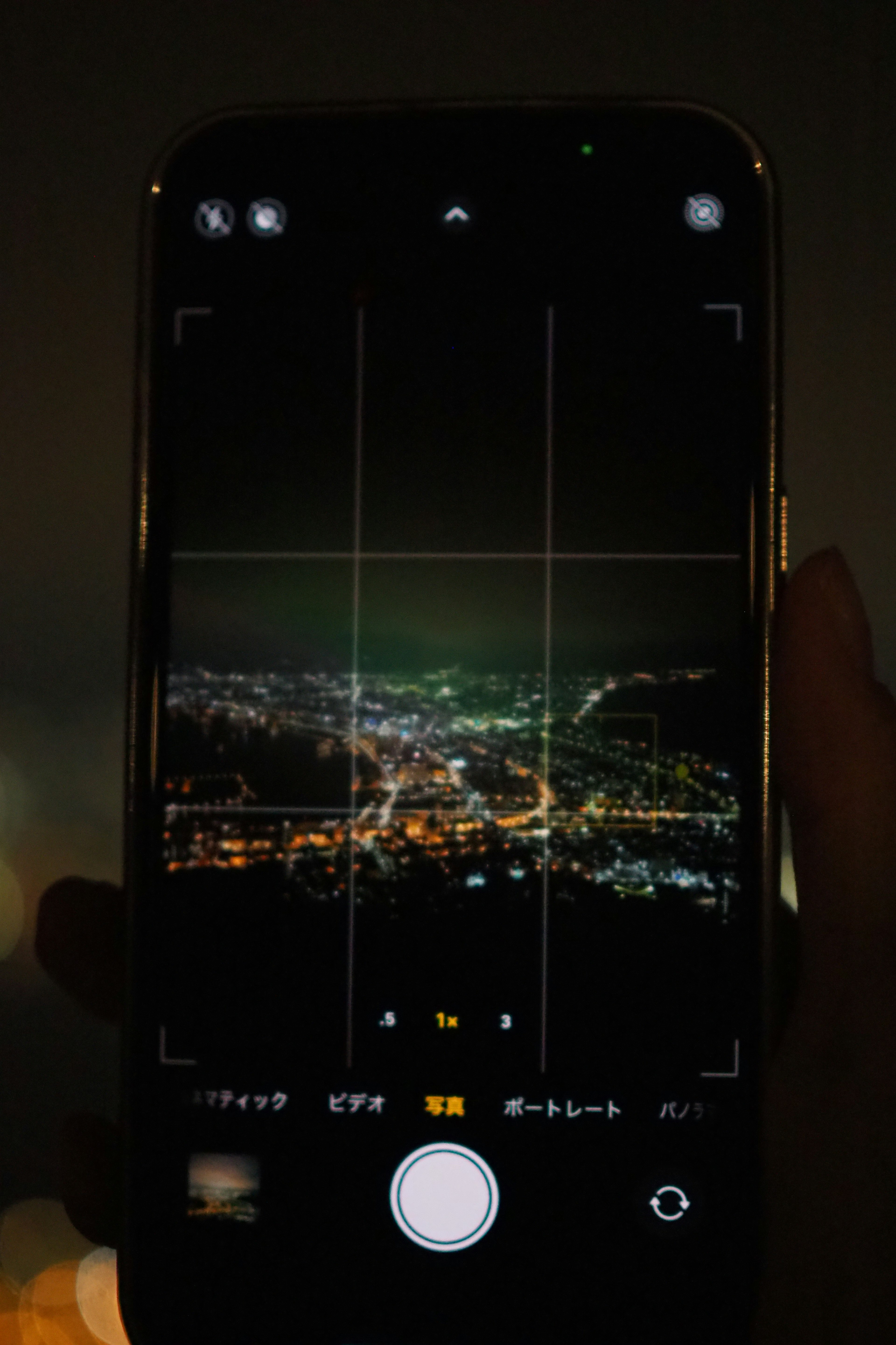 Smartphone camera app showing a cityscape at night under a dark sky