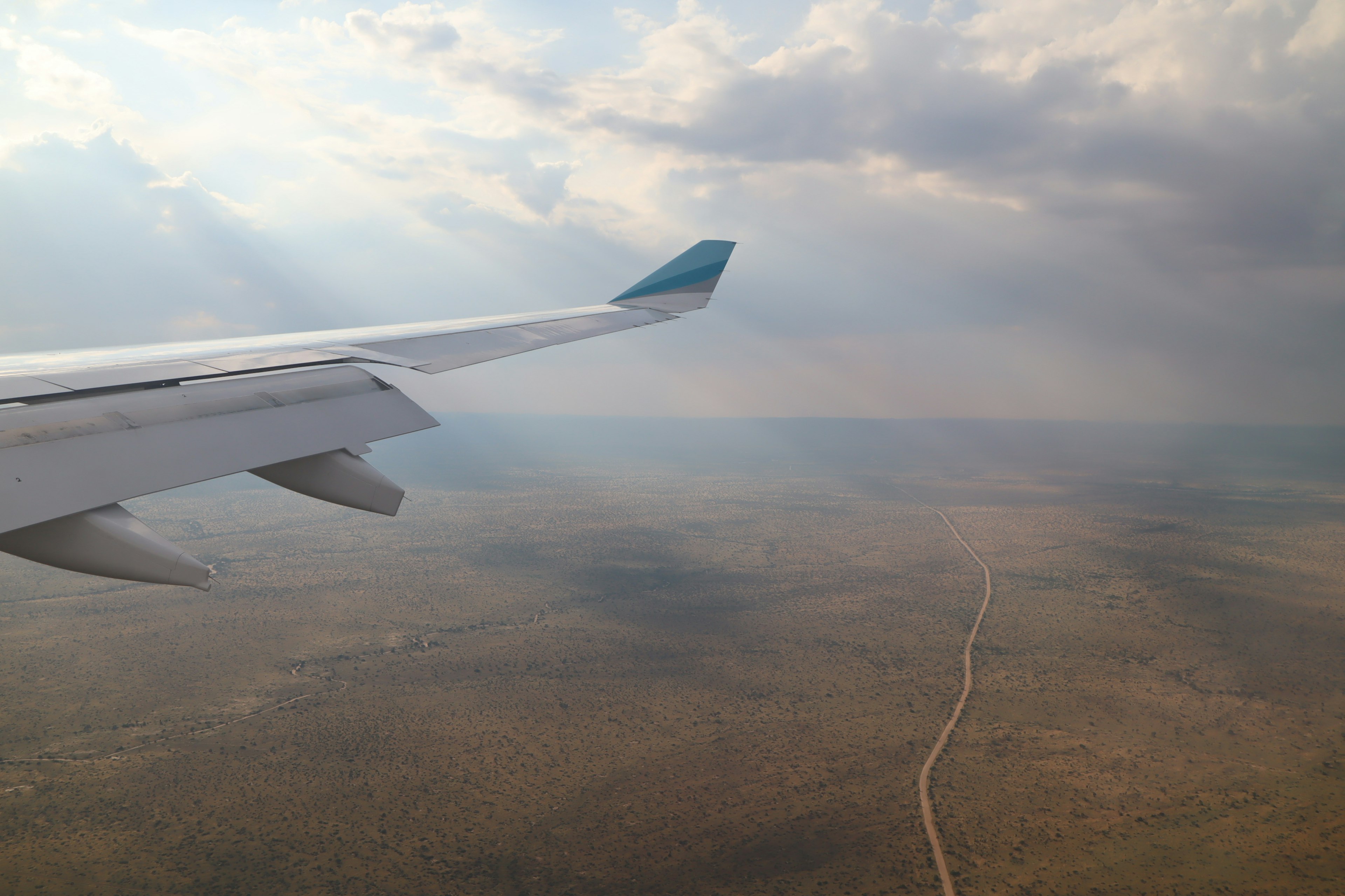 Airplane wing with expansive landscape below