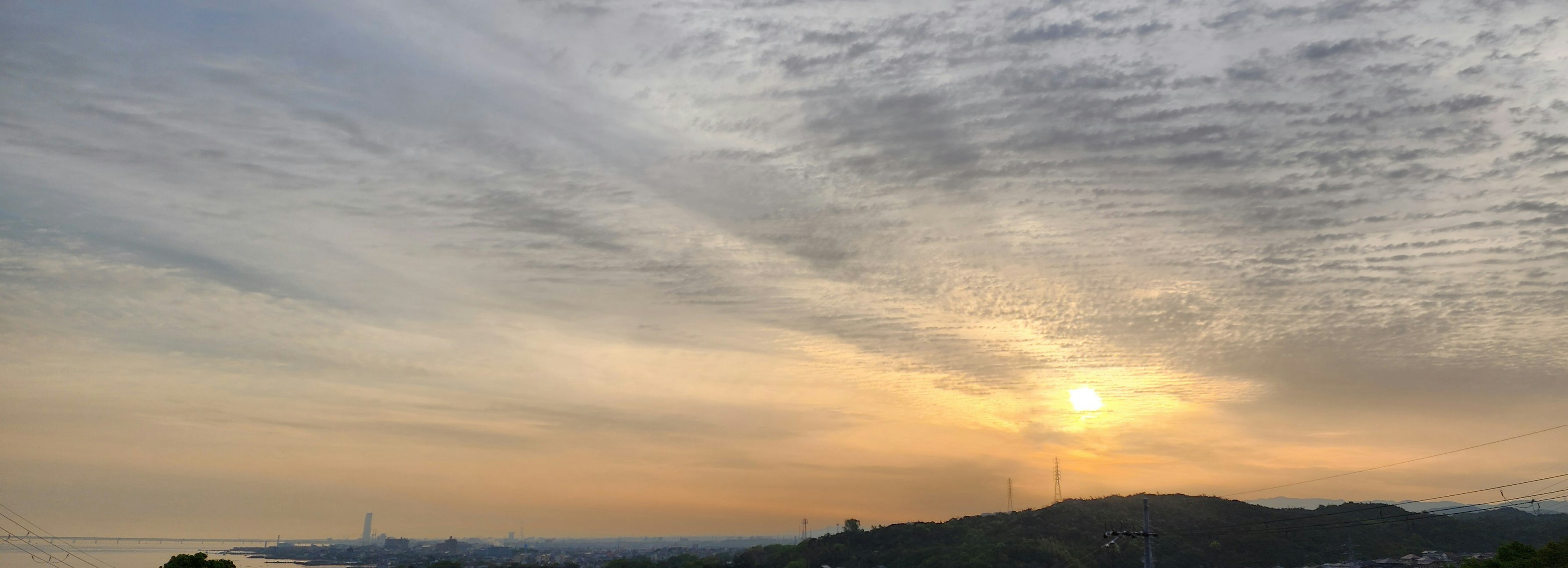 Paysage avec un coucher de soleil et des nuages rayés