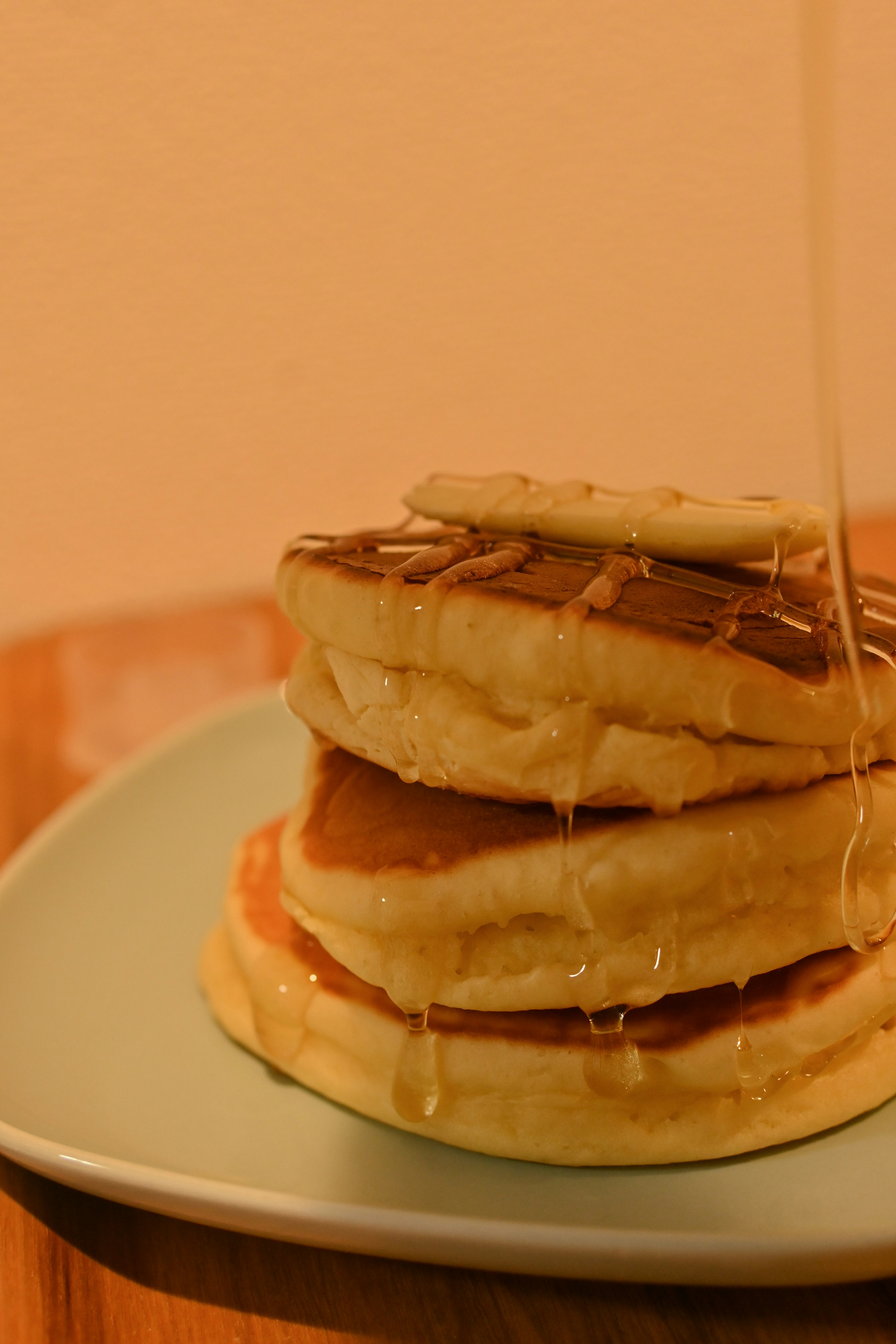 Stack of fluffy pancakes drizzled with maple syrup