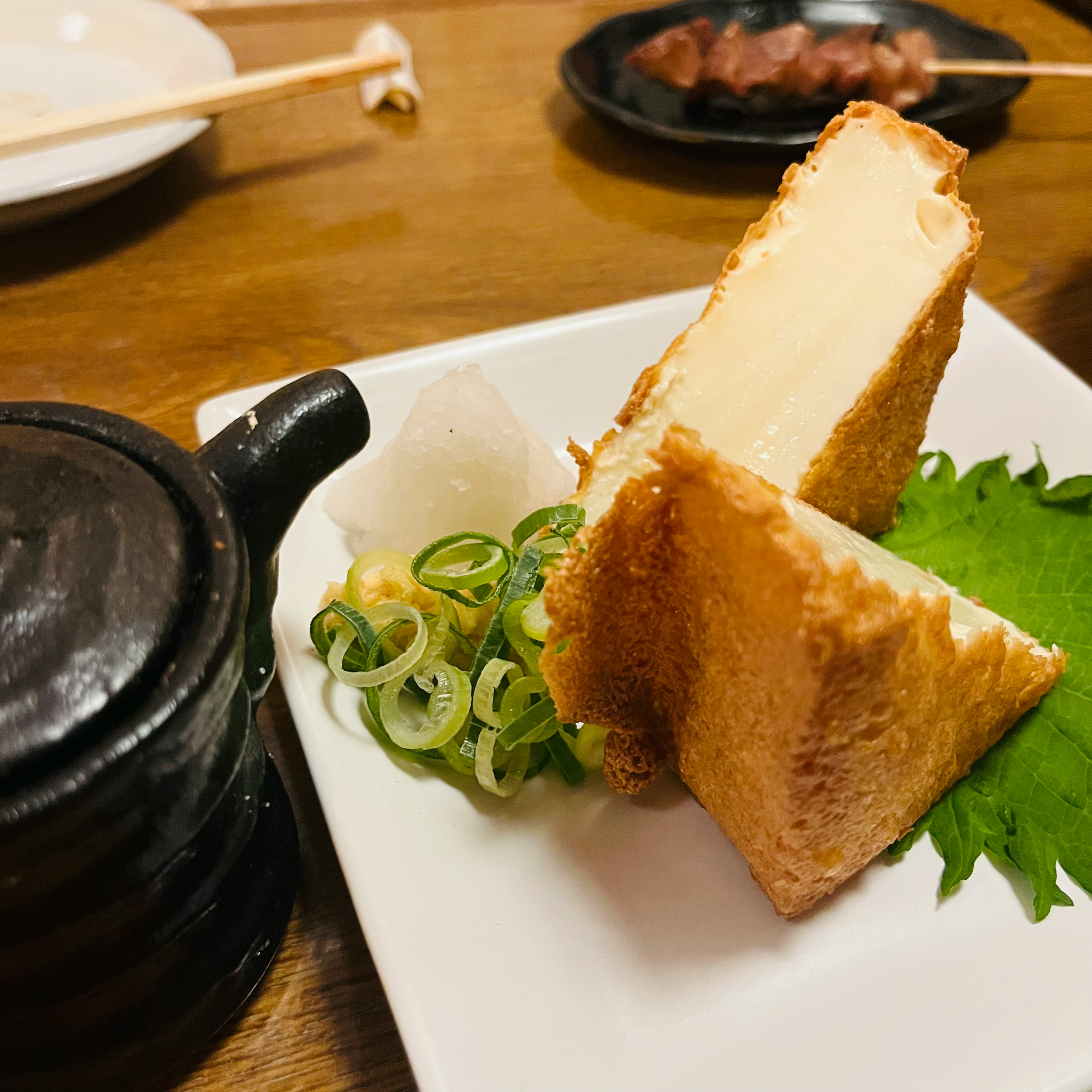 Sandwich de tofu frit avec des oignons verts et un petit pot