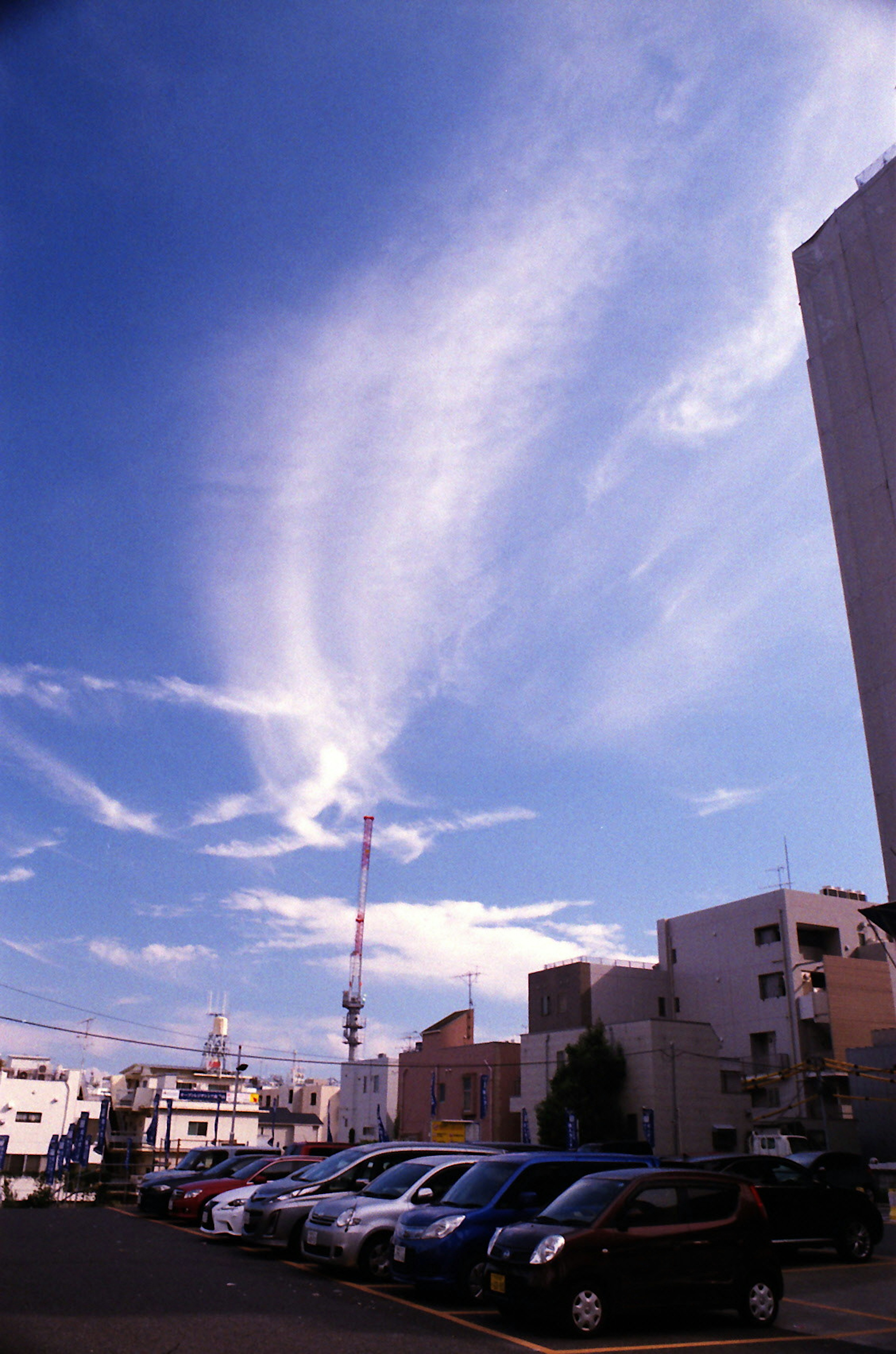 城市风景蓝天和白云停车场内停着汽车和建筑物可见