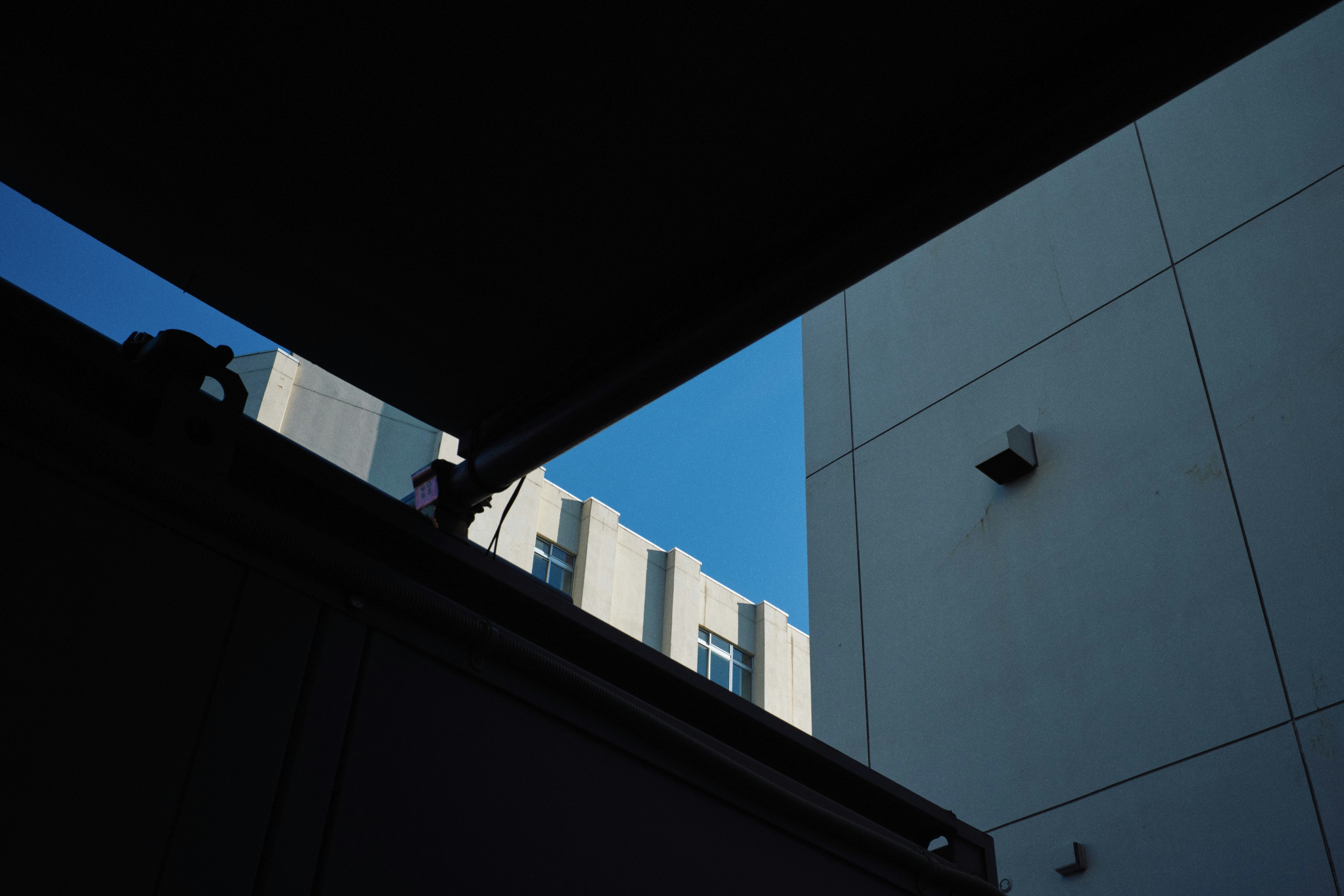 Vista del cielo azul a través de un espacio entre edificios