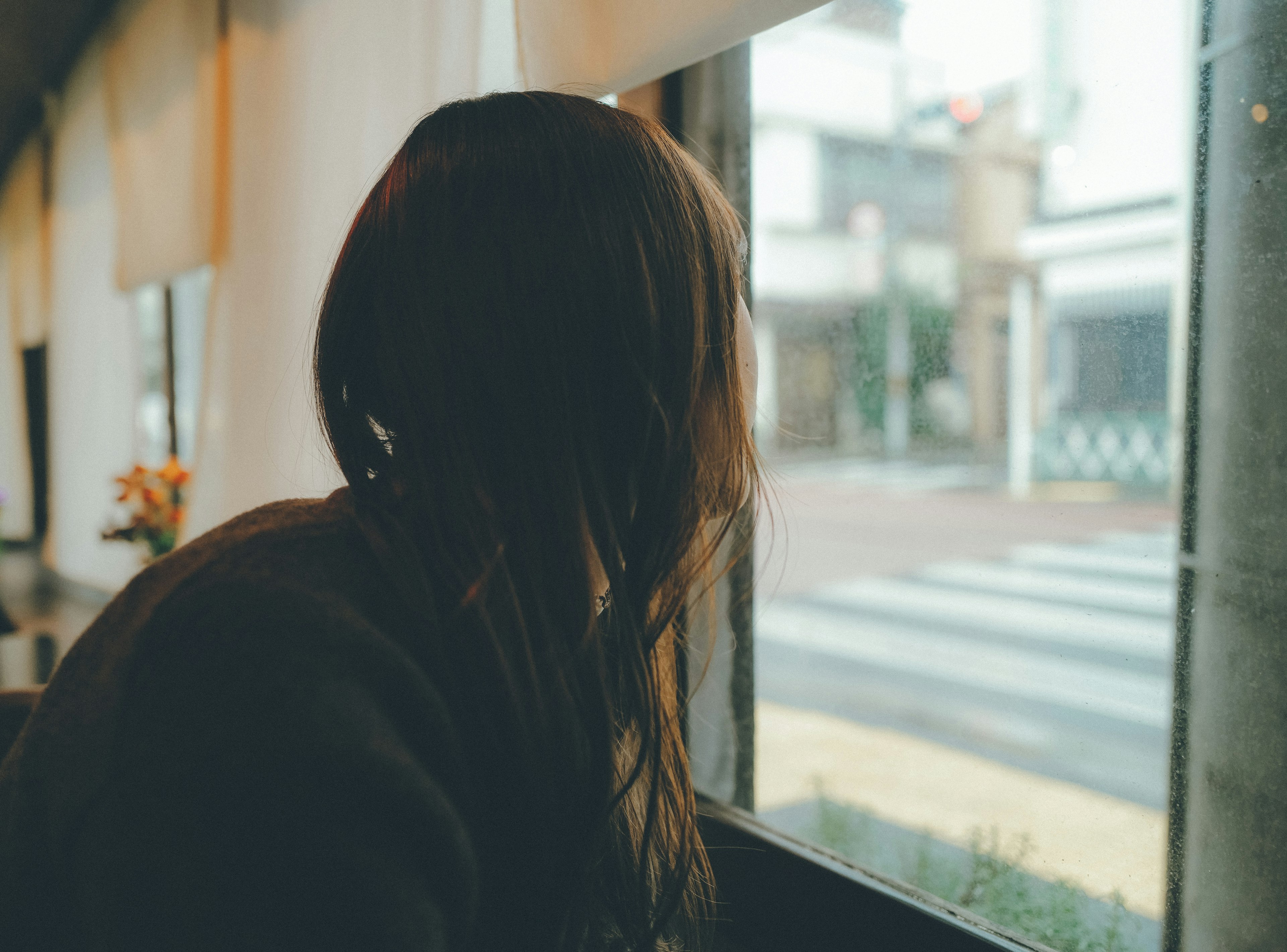 Frau schaut aus dem Fenster von einem Café