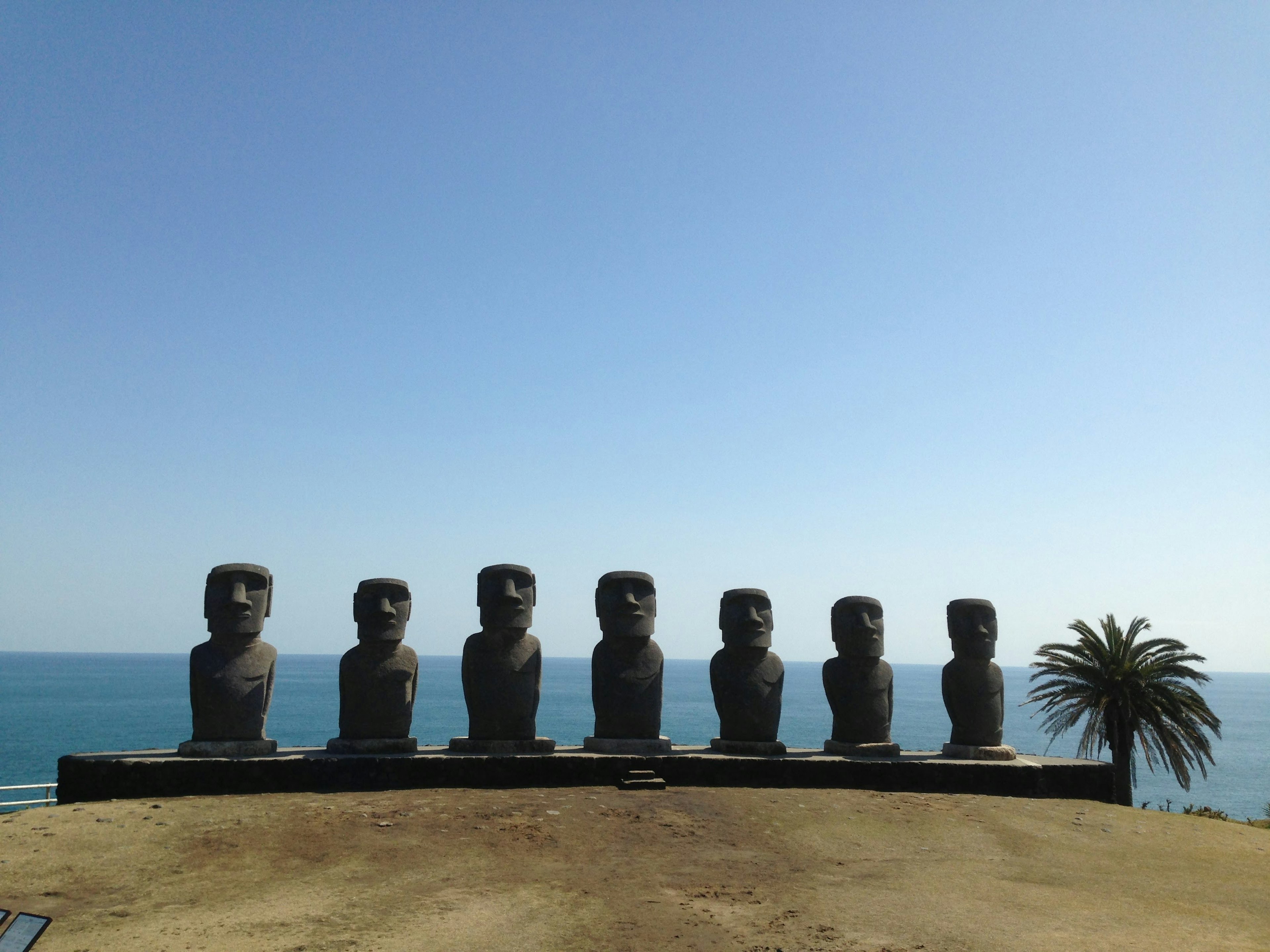 Row of Moai statues from Easter Island overlooking the ocean