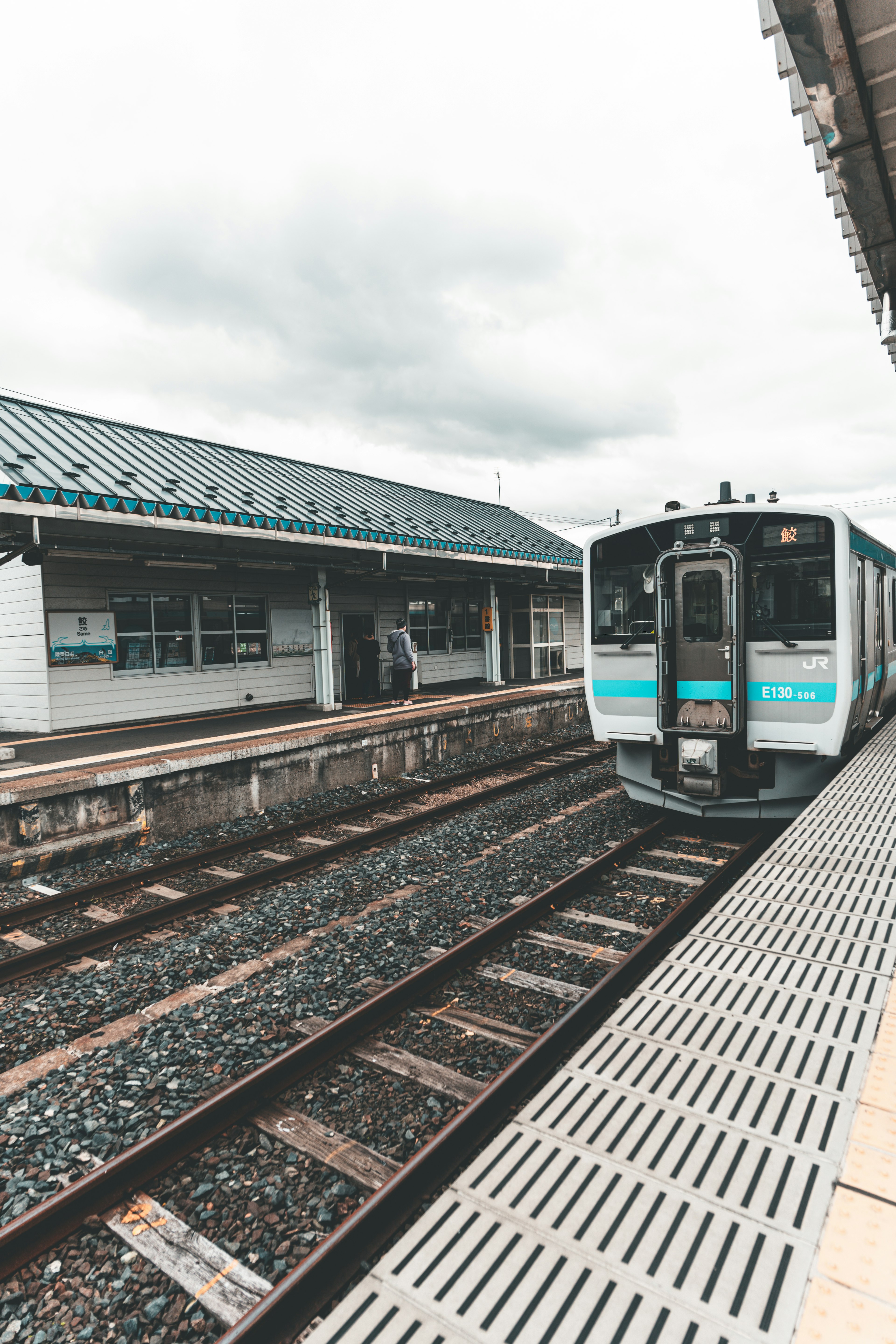 Tren detenido en una estación tranquila bajo un cielo nublado