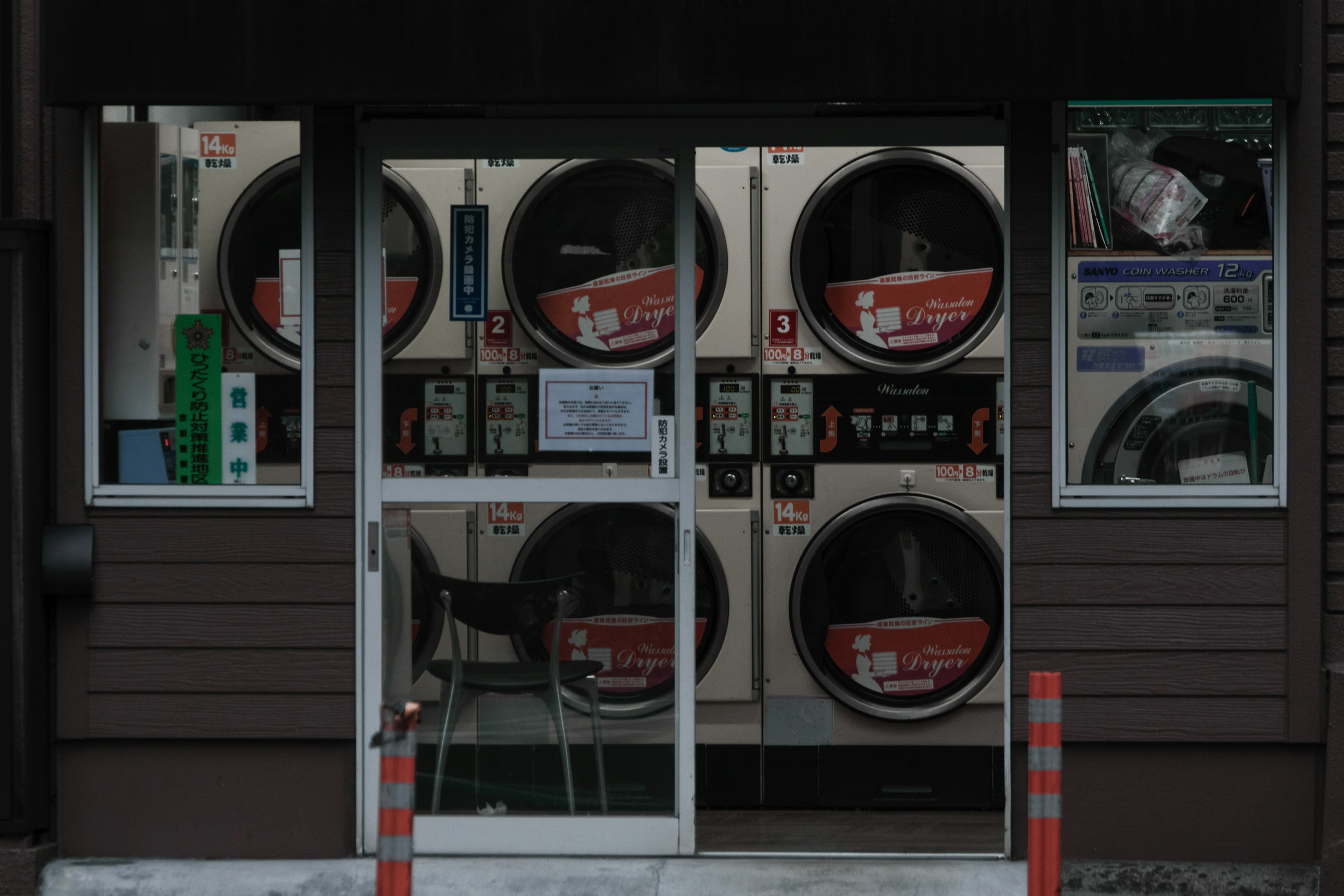 Extérieur d'une laverie automatique avec plusieurs machines à laver et des portes en verre